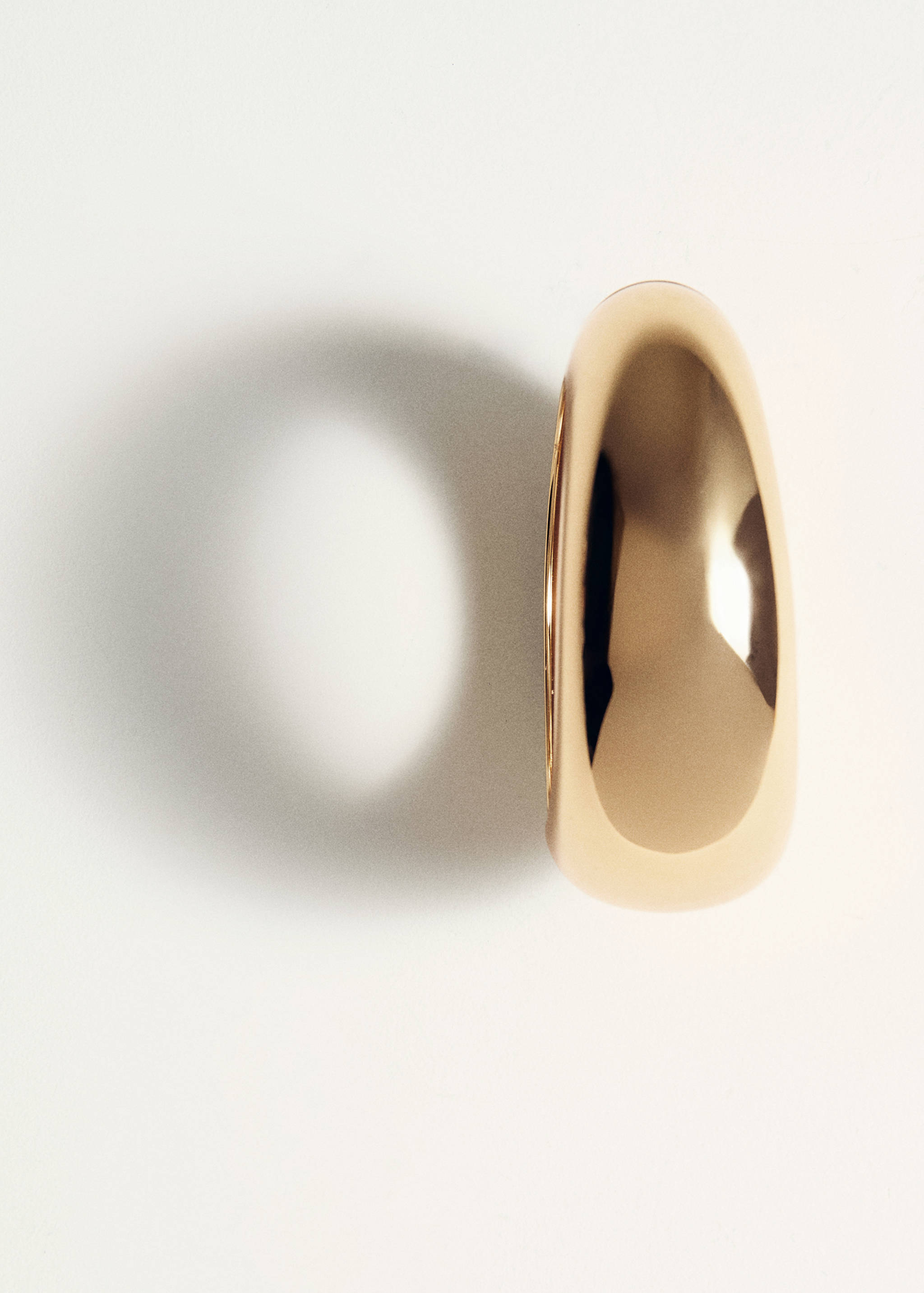 Chunky gold-tone bracelet in a close-up studio shot.