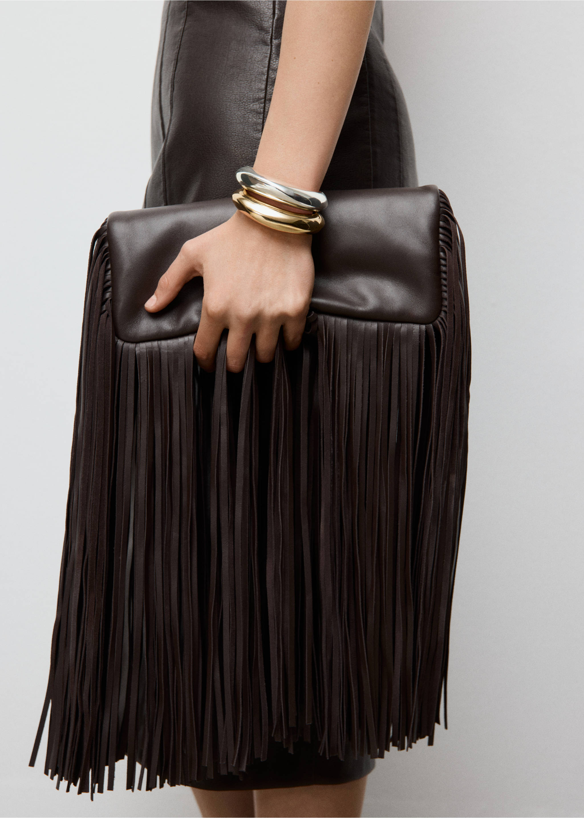 Chunky silver and gold-toned bangles worn on a wrist., Gold. Ref: 27091287-00.
