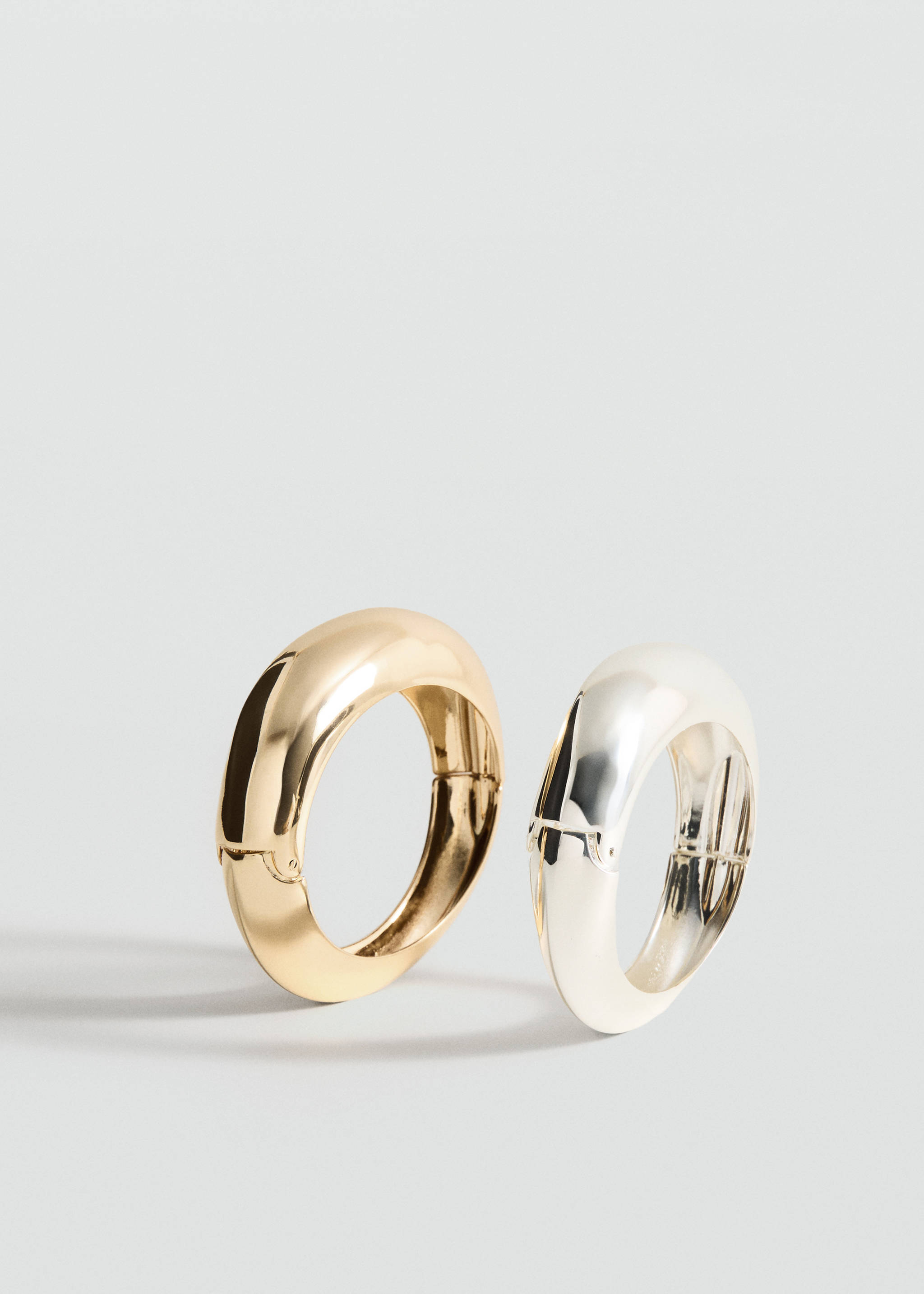 Chunky gold-tone and silver-tone metal hinged bracelets.