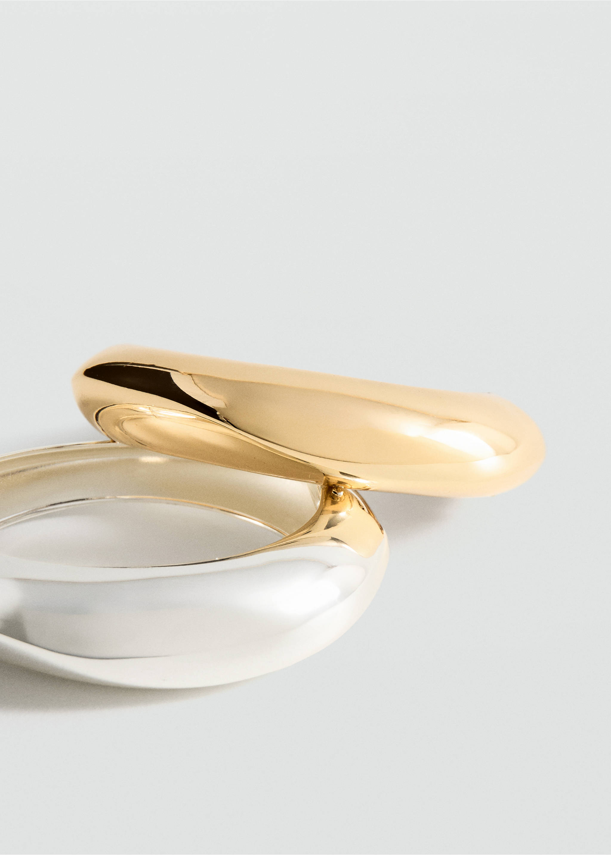 Close-up of a polished gold and a silver chunky metallic bangle., Gold. Ref: 27091287-00.