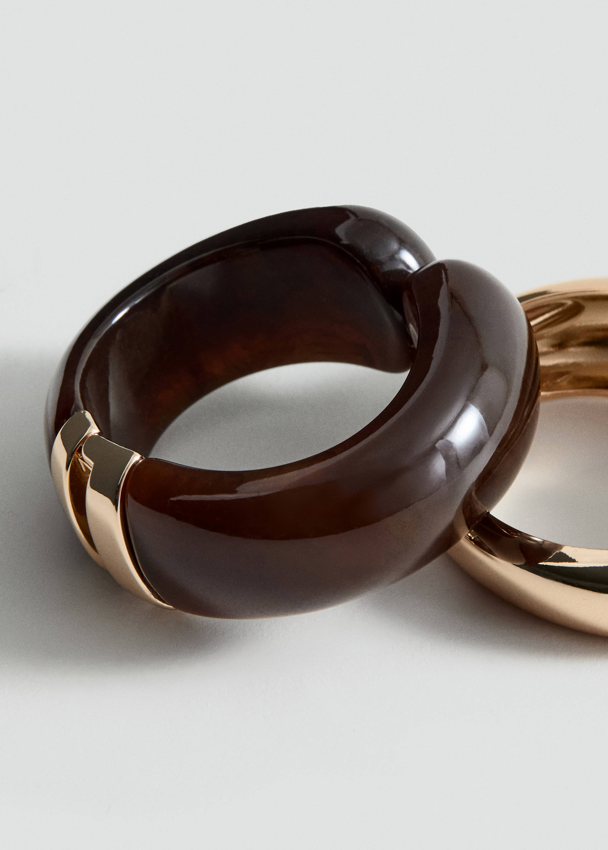 Thick dark brown resin bracelet with a gold-toned metal hinge.
