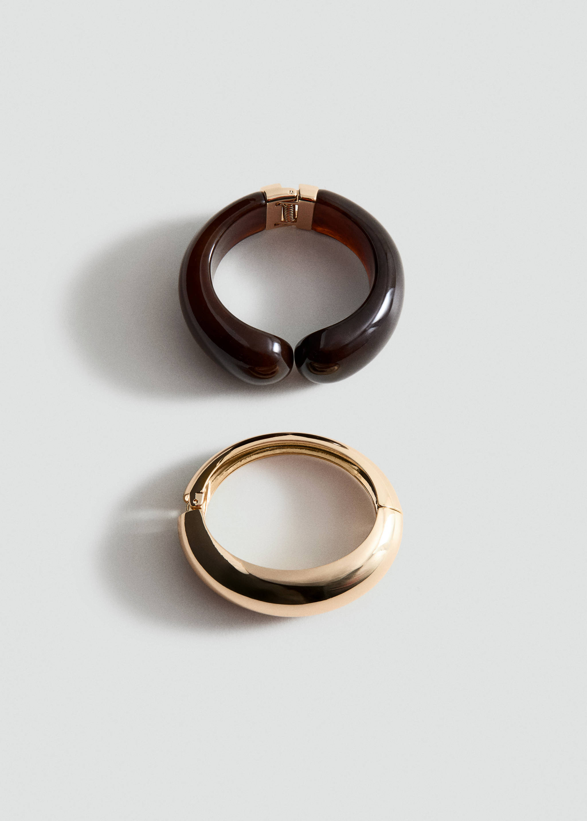 Set of two chunky hinged bracelets in dark tortoiseshell and polished gold-tone metal.