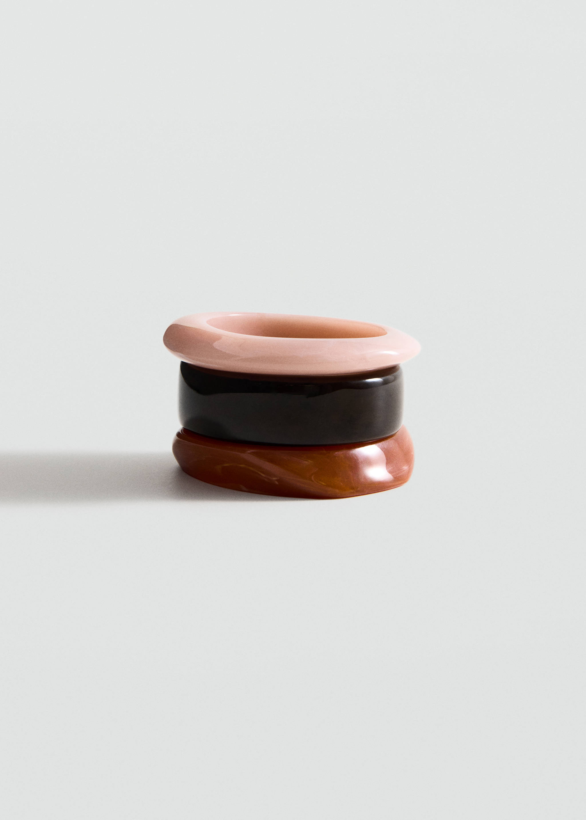 Set of three chunky resin bracelets in pale pink, dark brown, and marbled tortoiseshell.