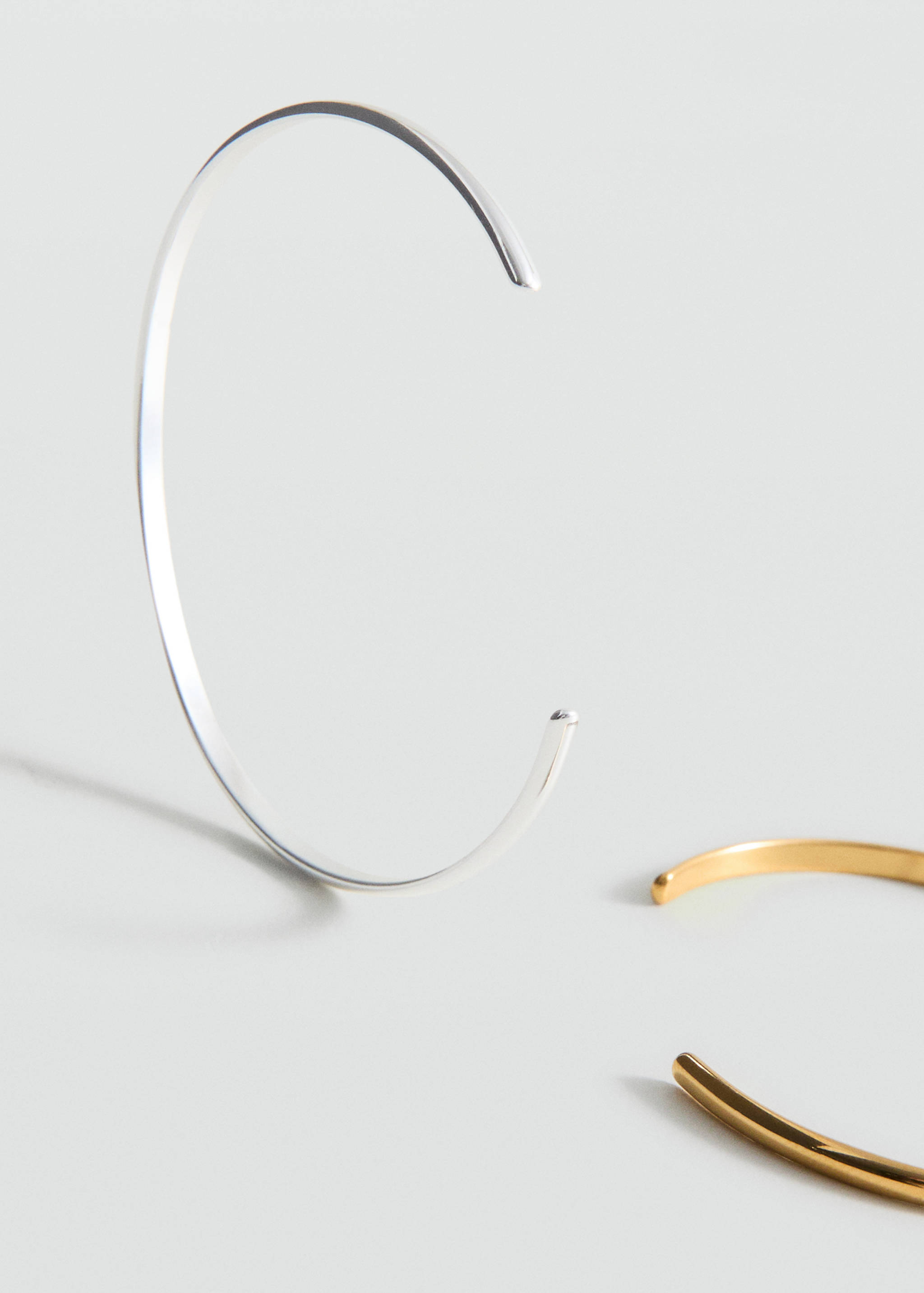 Silver-coloured metal cuff bracelet detail.
