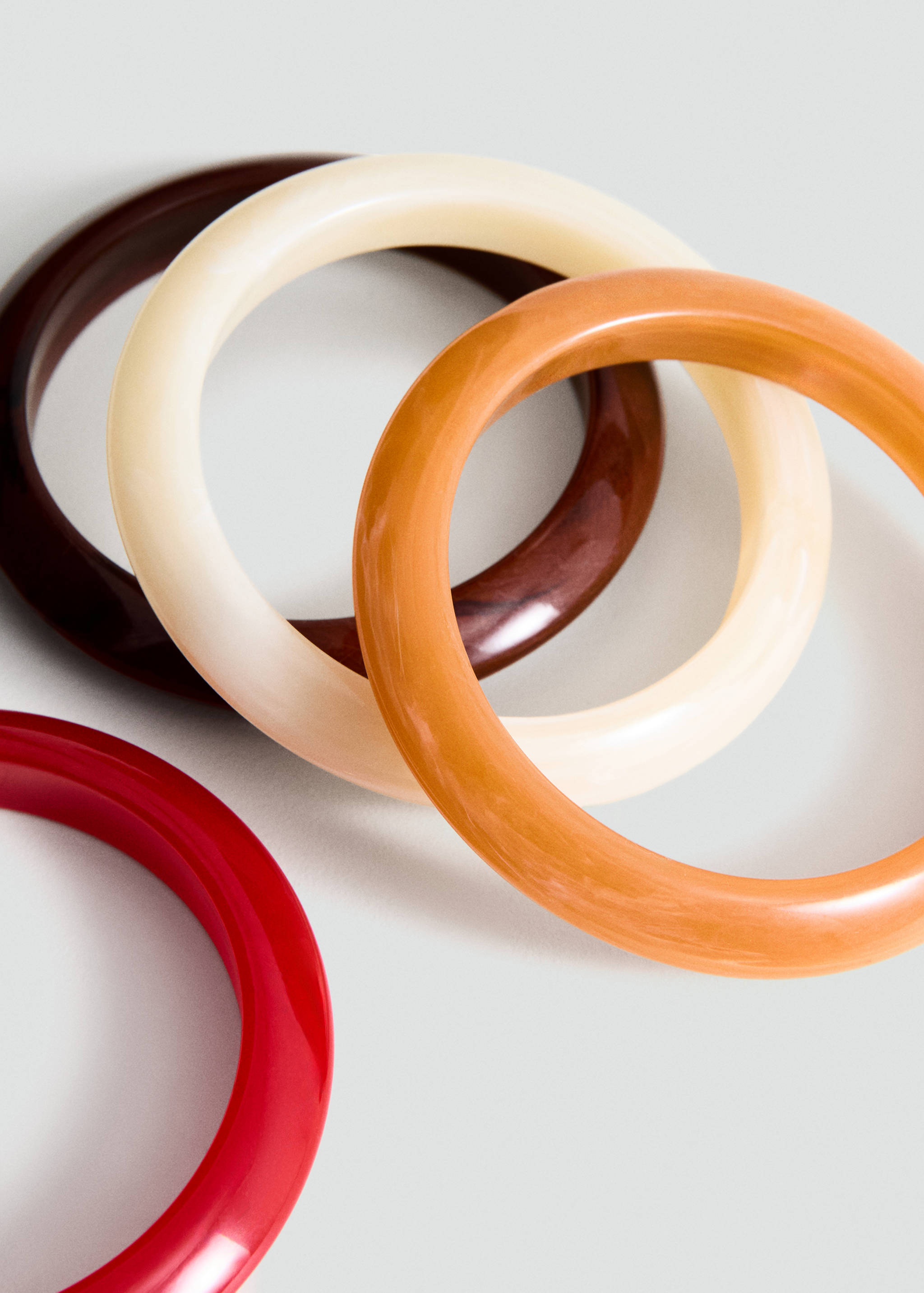 Set of four thick, glossy resin bangles in assorted colours.
