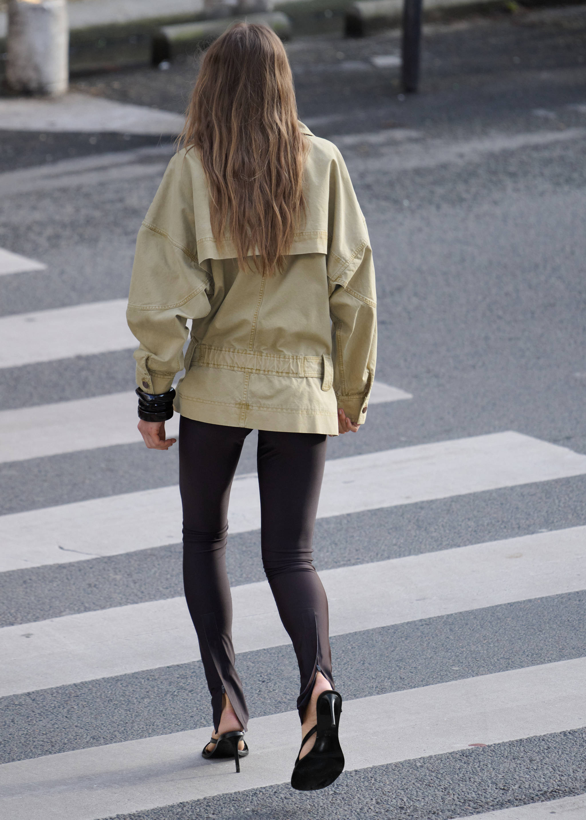 Parka caqui de diseño fluido, vista de espaldas en una modelo.