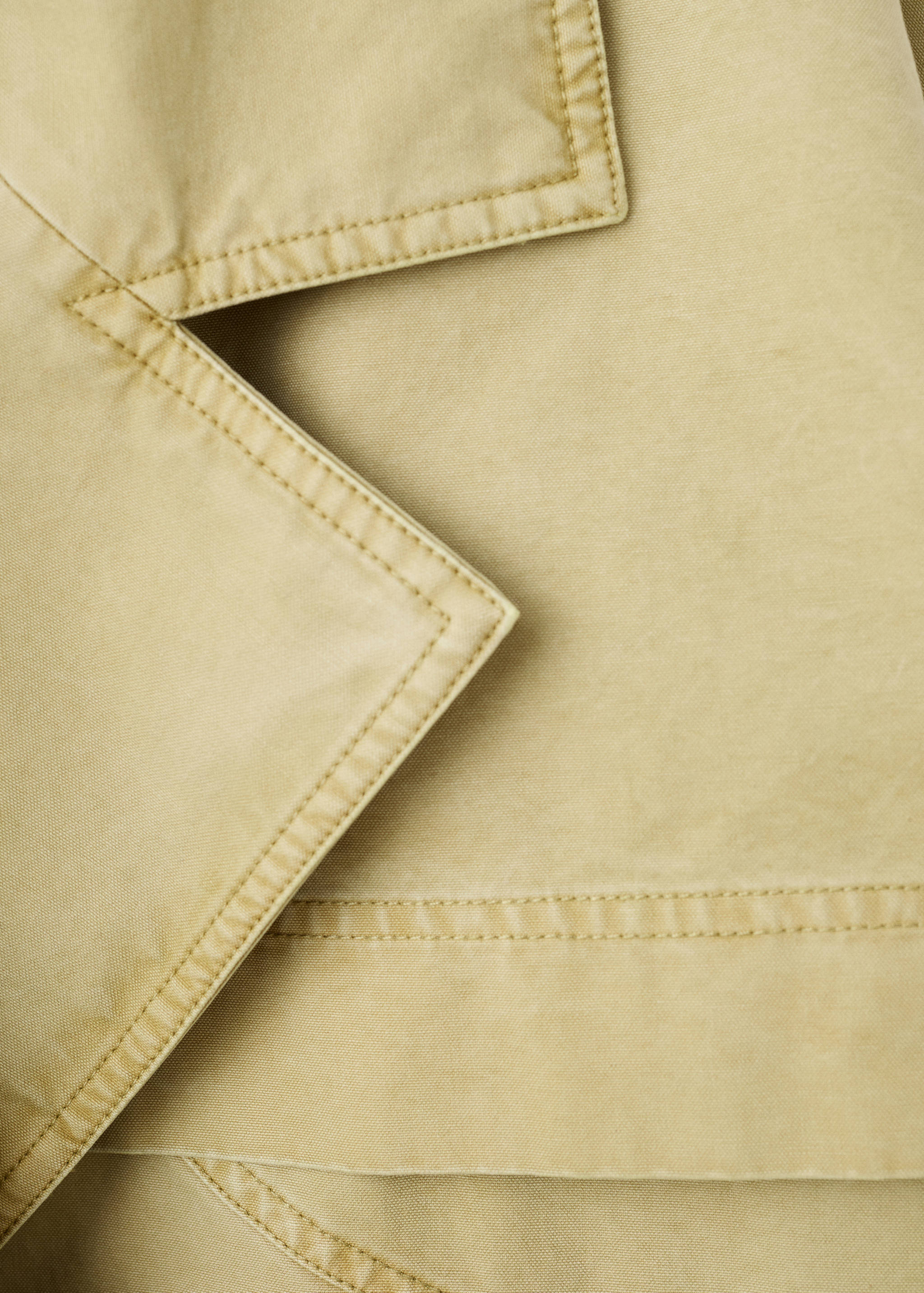 Detalle de solapa de parka beige con pespuntes.
