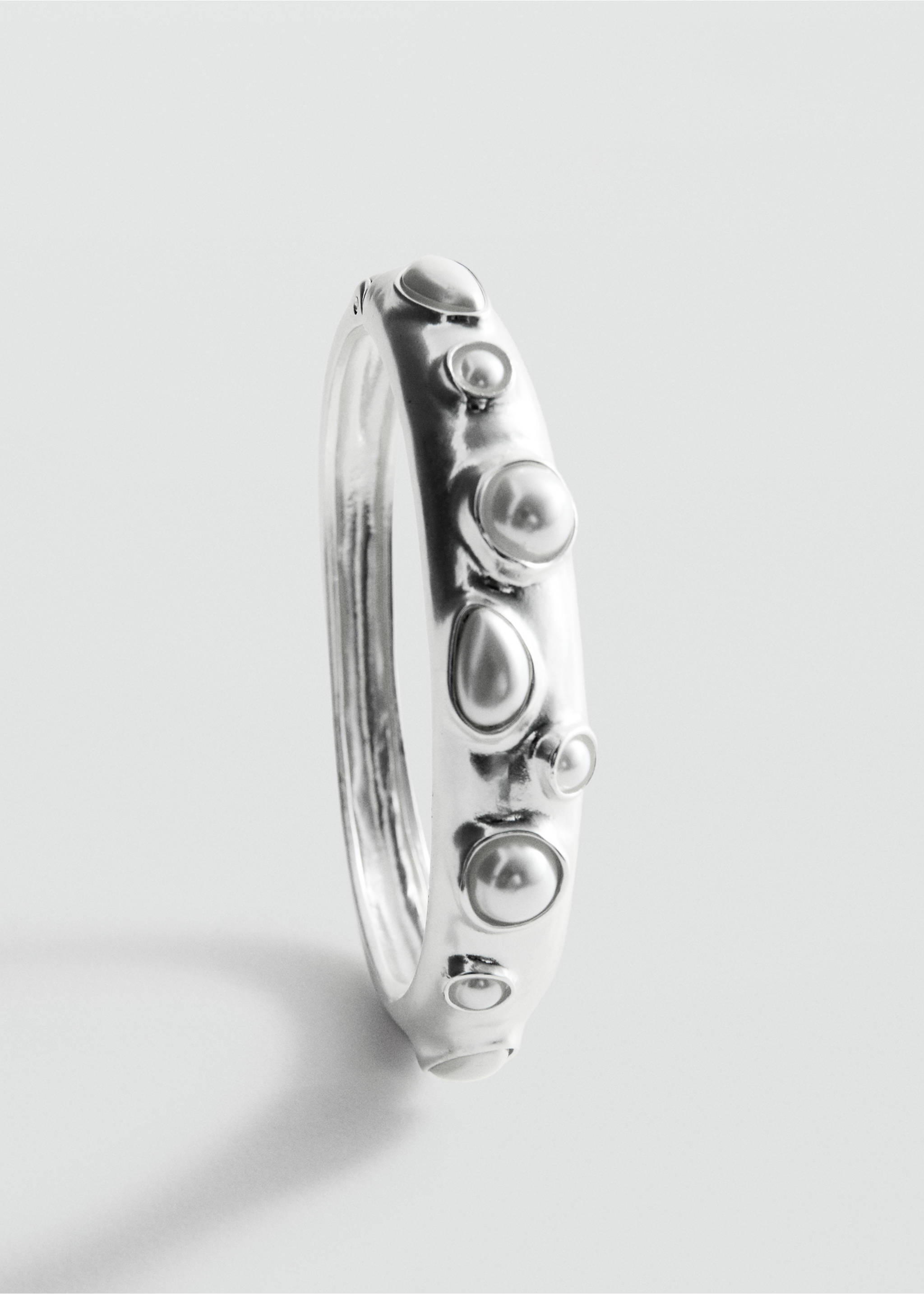 Close-up of a silver-coloured rigid bracelet with embedded pearl-like beads., Silver. Ref: 27097796-00.
