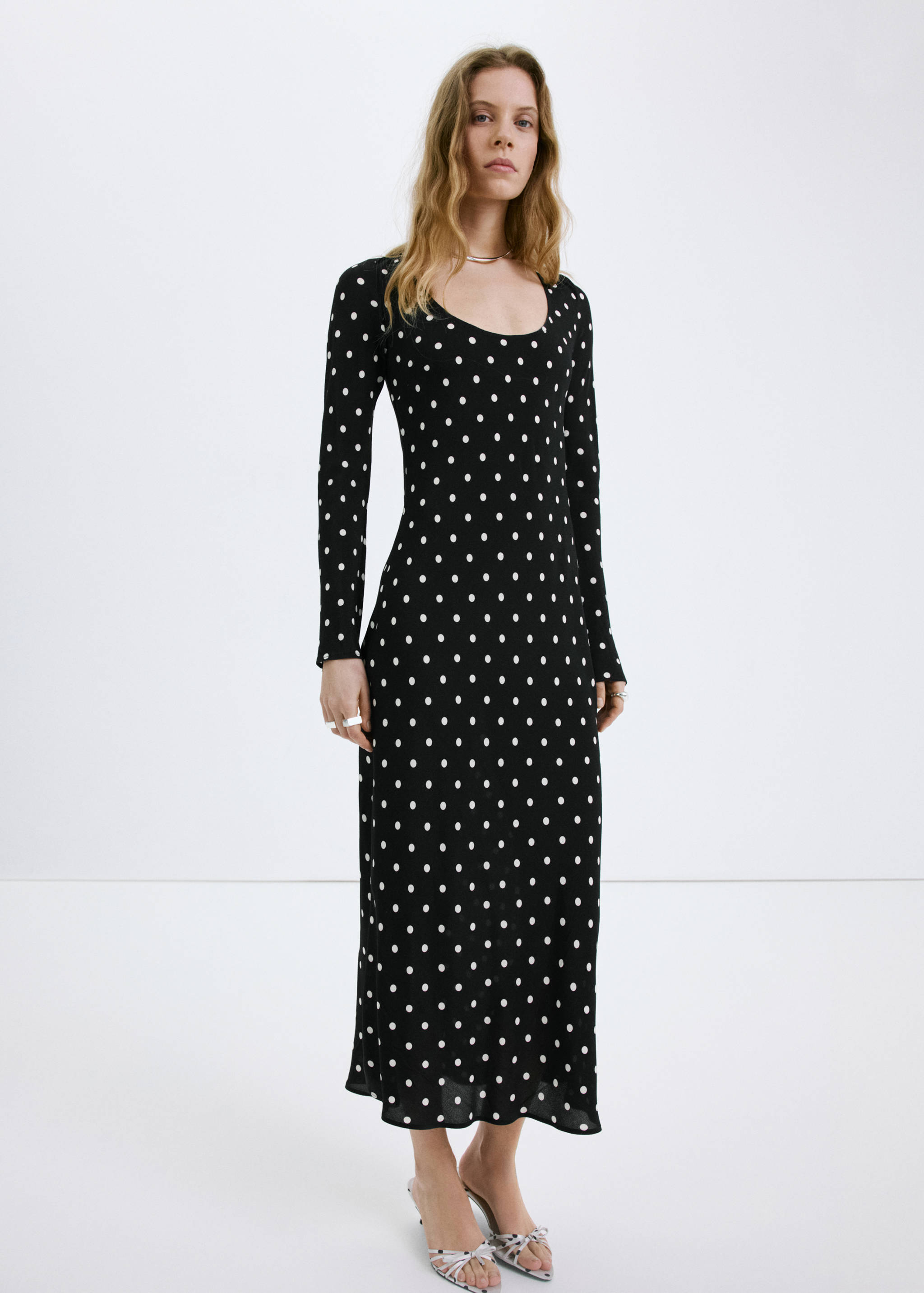 Black polka dot long-sleeved maxi dress with a scoop neckline.