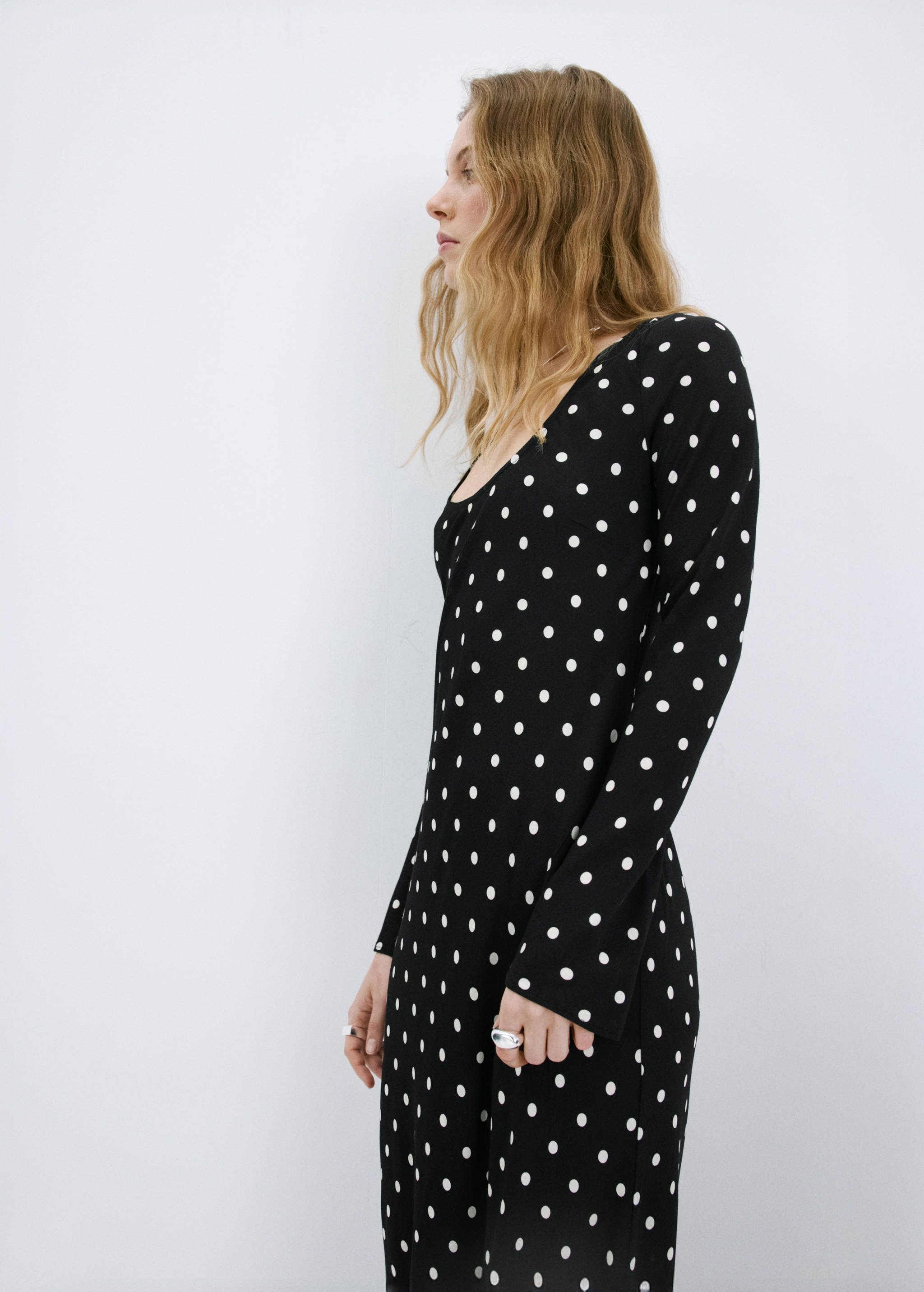 Black polka dot long-sleeved midi dress with a scoop neckline.