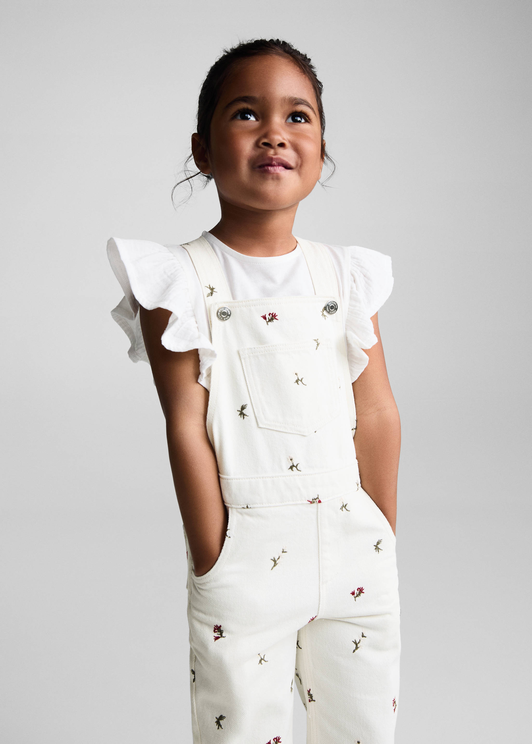 Broderade hängselbyxor i denim - Bild av mittparti