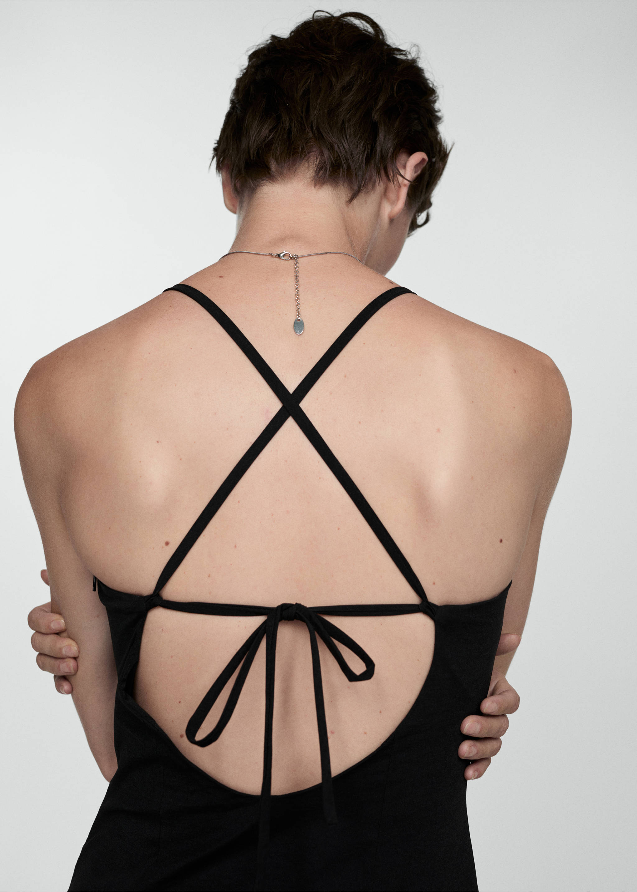 Pleated dress with crossed back - Details of the article 1, Black. Ref: 77044026-00.