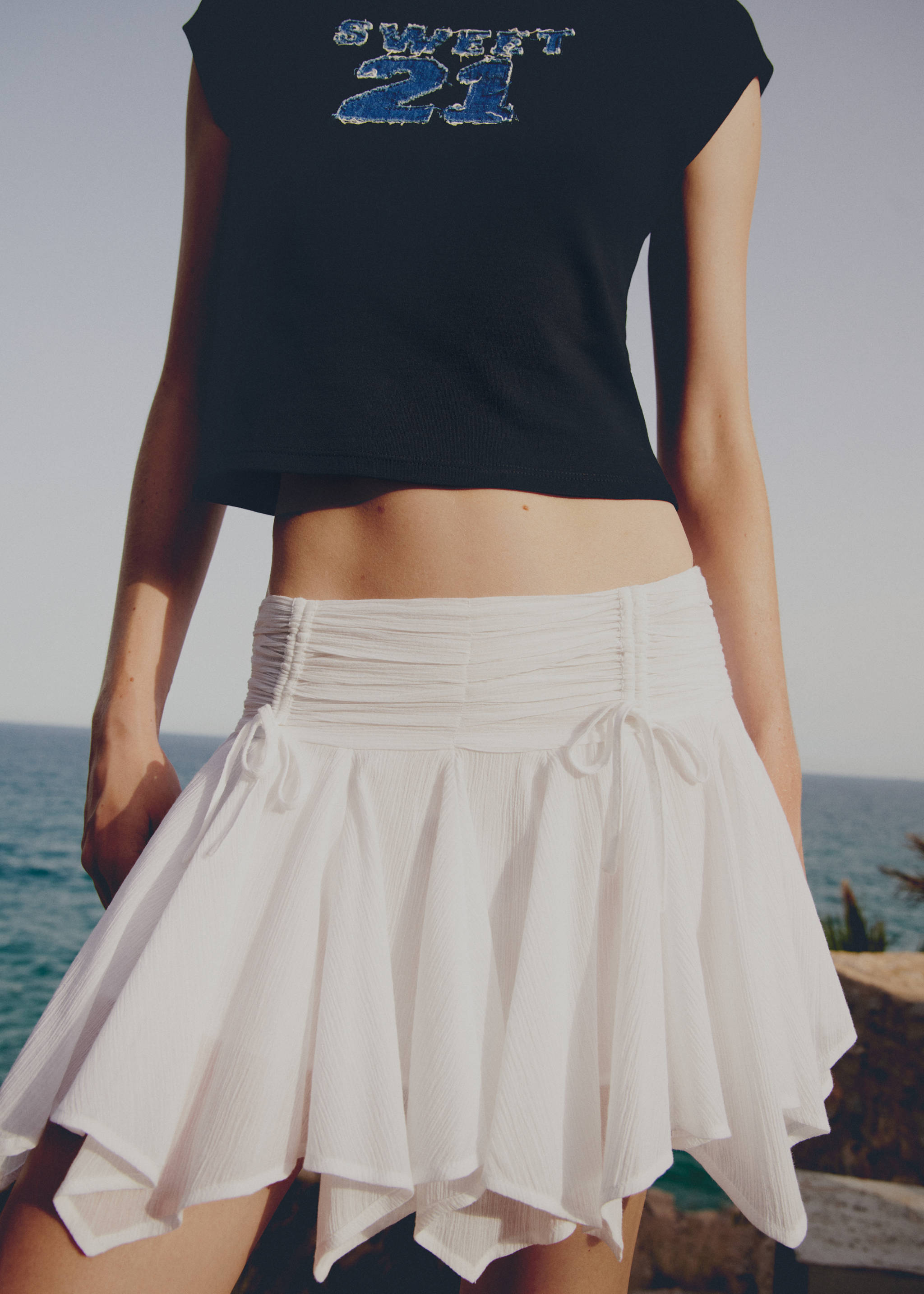 Asymmetrical mini-skirt with bows - Details of the article 7, White. Ref: 77071505-00.
