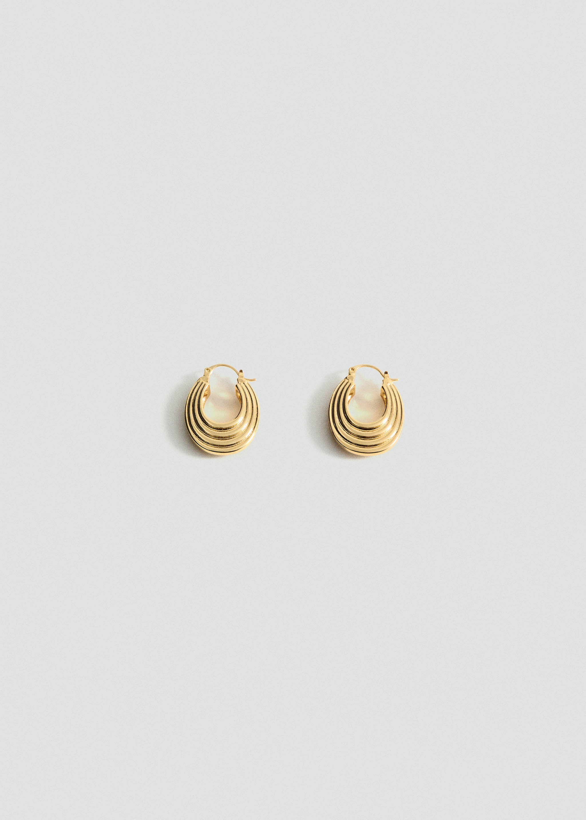 Pair of thick gold hoop earrings with a ribbed layered design.
