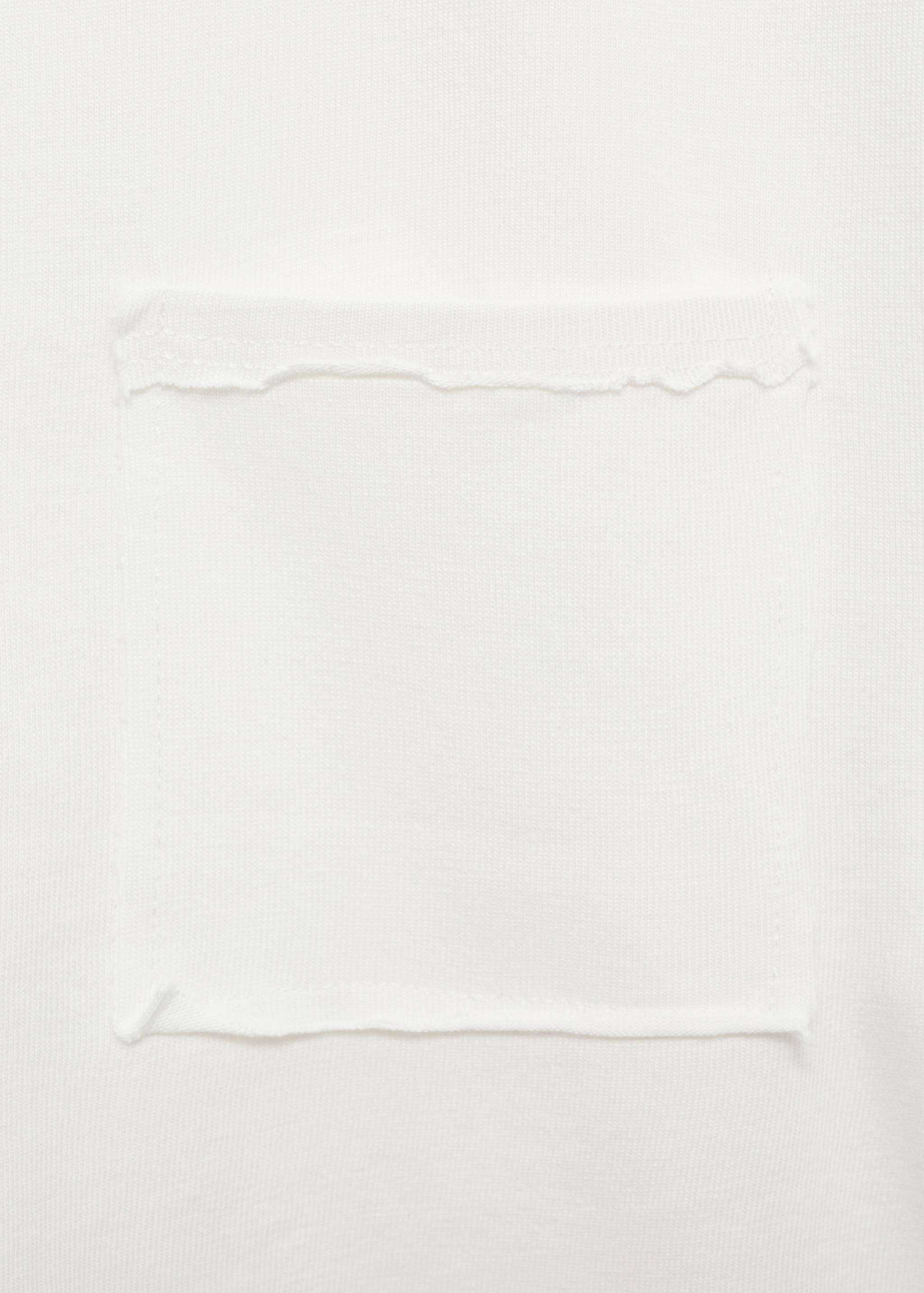 Close-up of white t-shirt fabric showing a patch pocket detail.