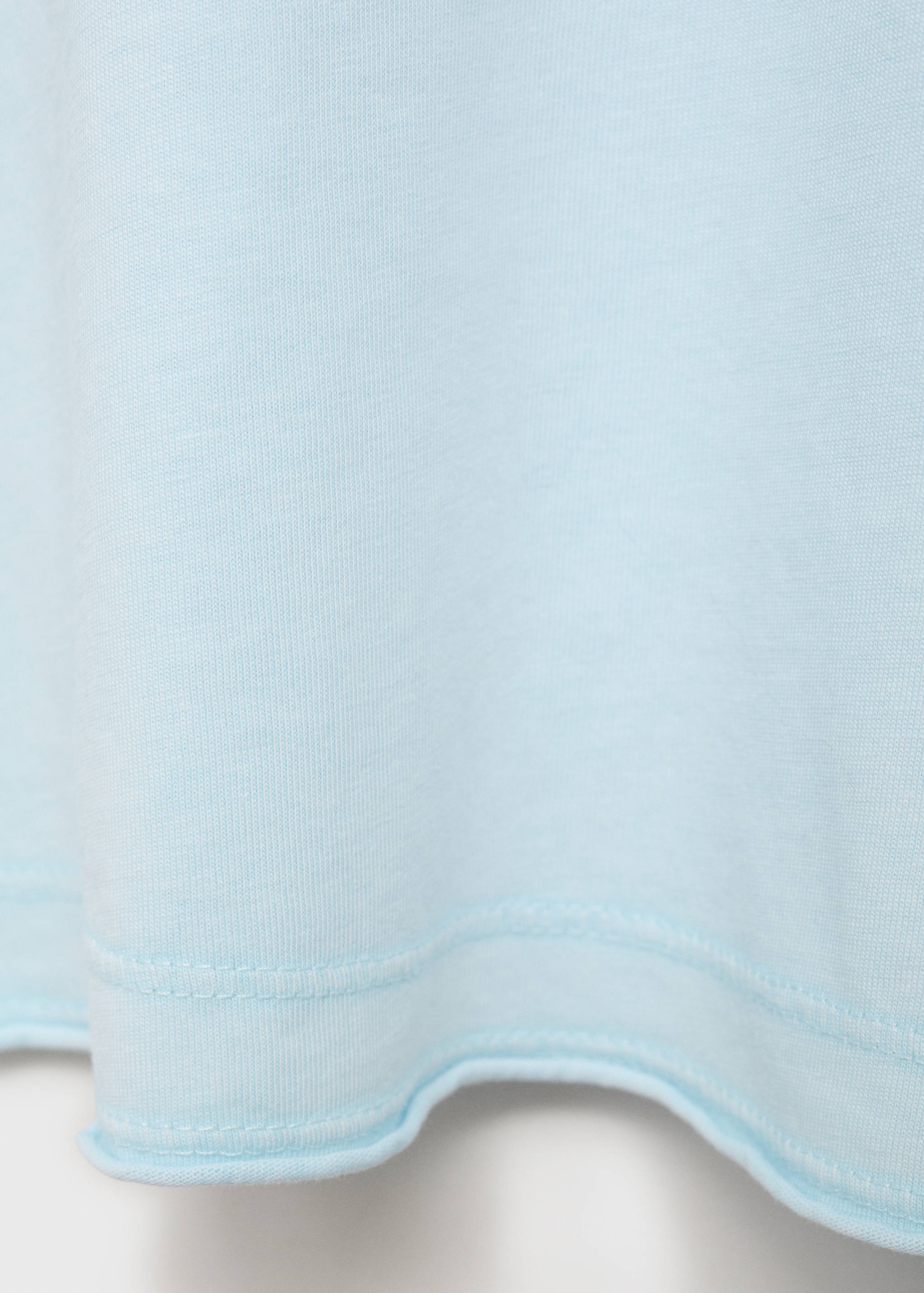 Light blue t-shirt fabric detail with a raw hem