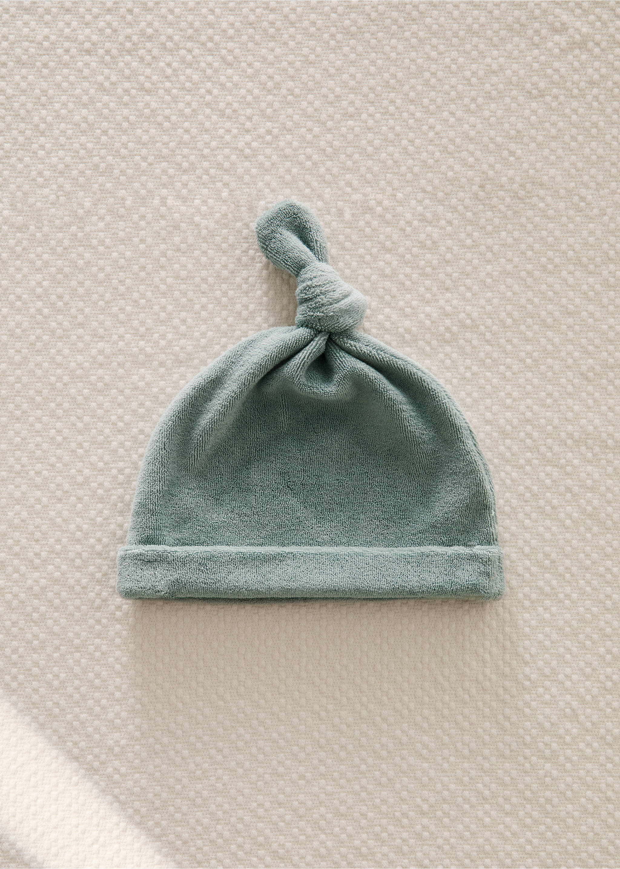 Green terry baby hat with a folded brim and a top knot., Mint Green. Ref: 87023657-00.