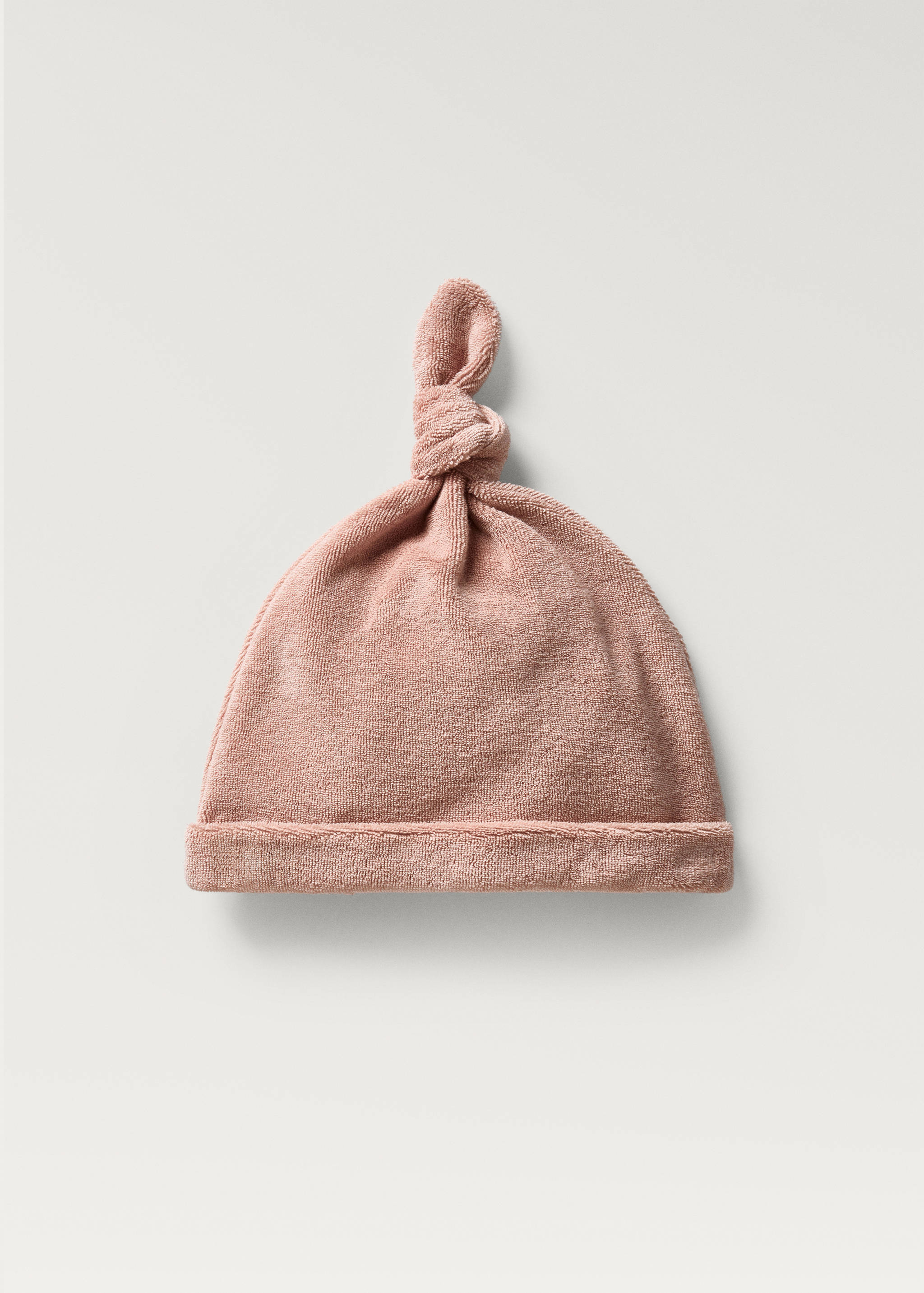 Pink towelling baby hat with rolled brim and top knot.