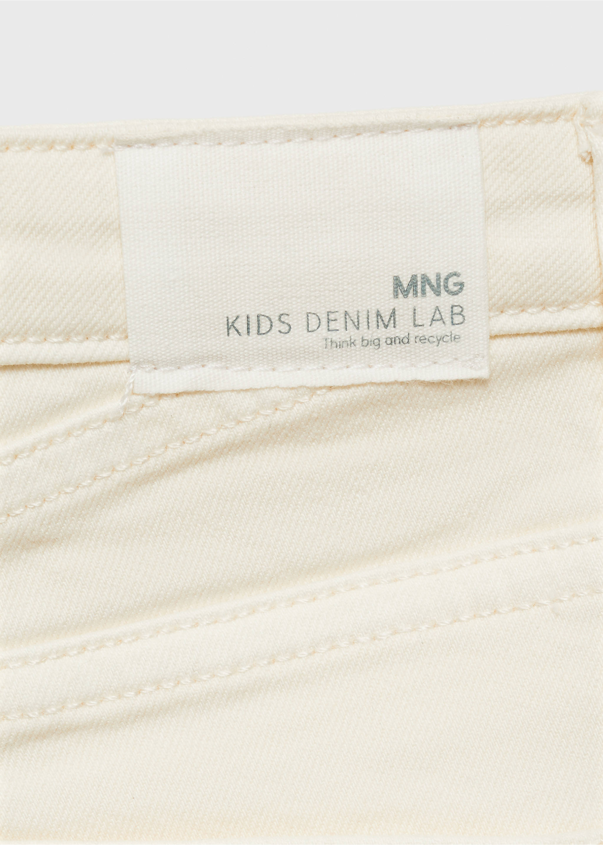Close-up of cream kids' denim shorts featuring a branded waistband label., White. Ref: 87025947-00.
