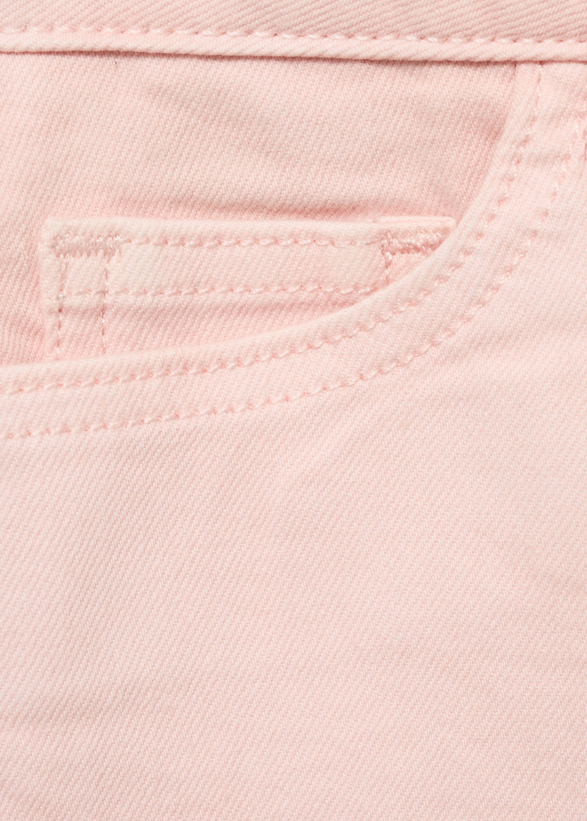 Close-up of pink shorts pocket detail.