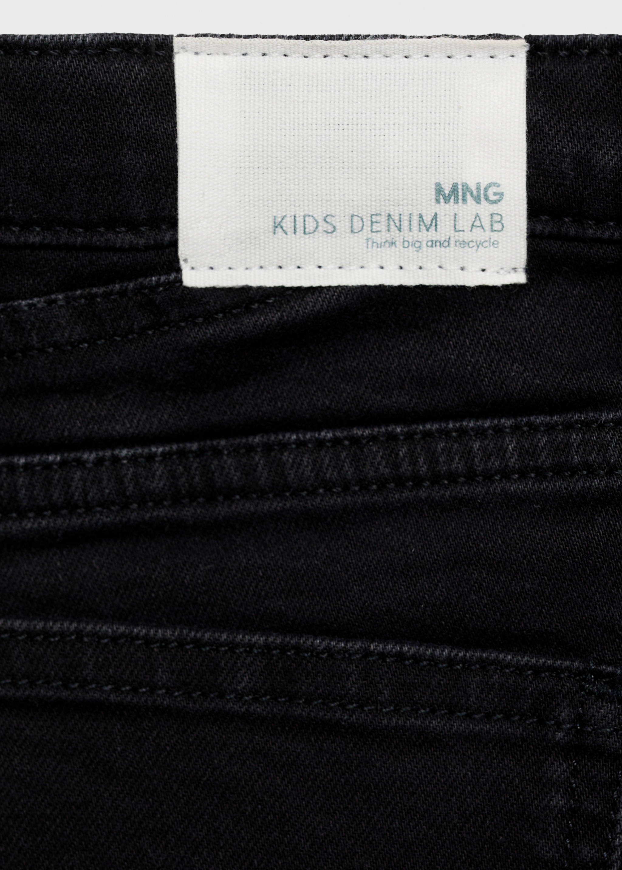 Close-up of black denim shorts featuring a Kids Denim Lab label.