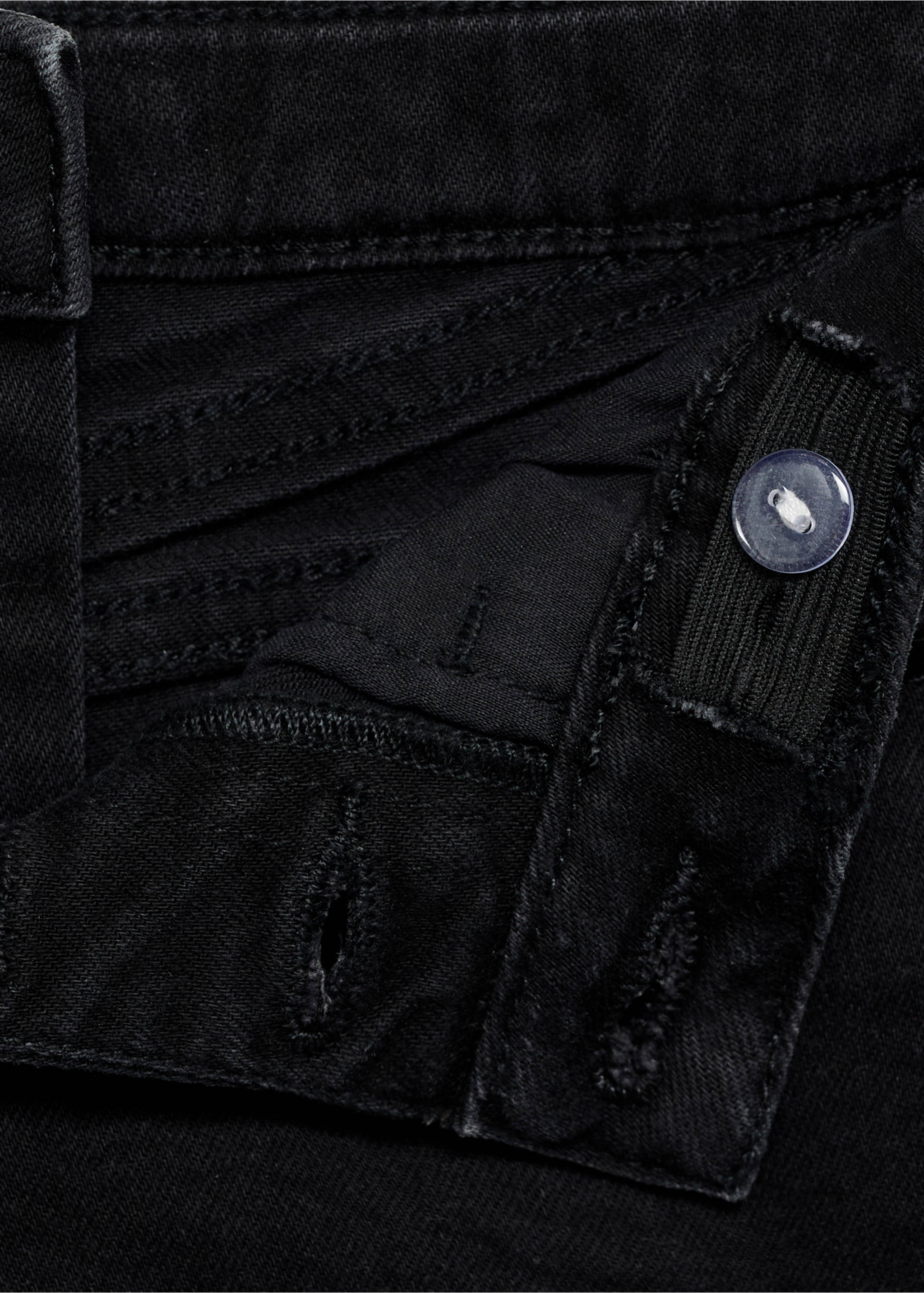 Close-up of black denim shorts featuring an adjustable waistband and button closure., Black denim. Ref: 87025947-00.