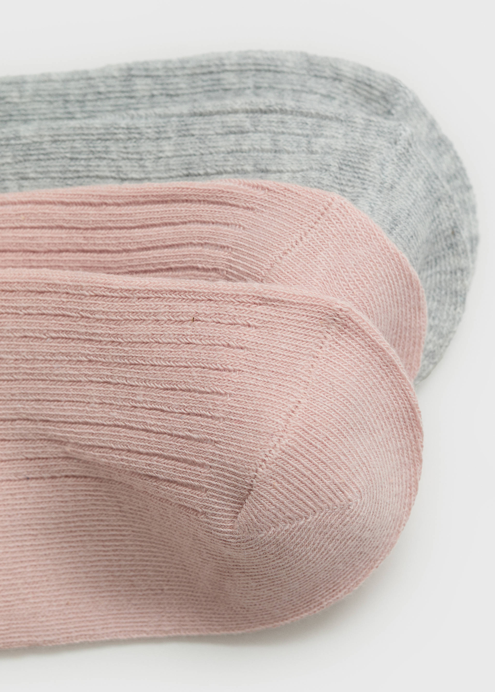 Close-up of soft pink and light grey ribbed socks.
