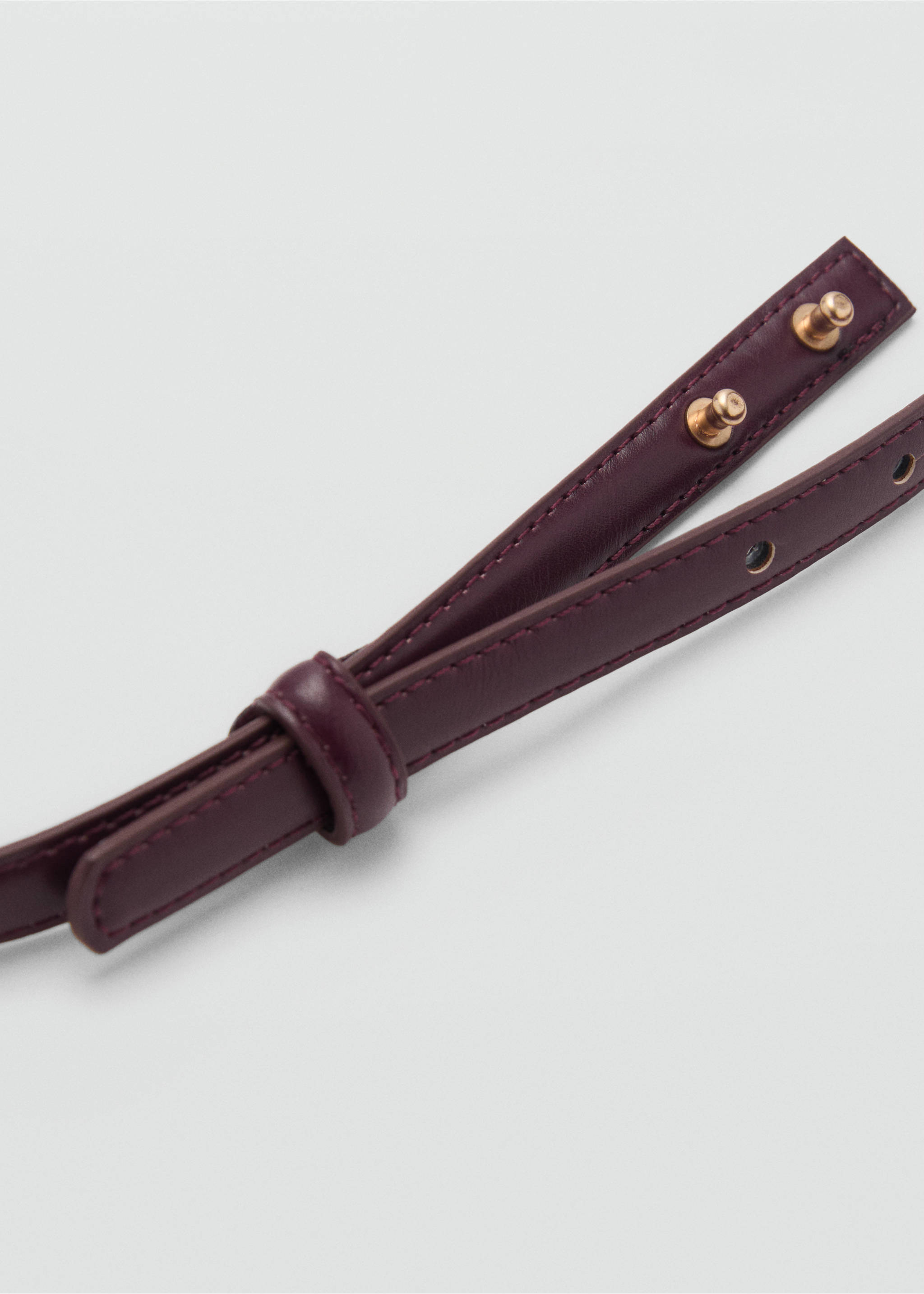 Close-up of a burgundy thin belt with gold-coloured stud closures., Burgundy. Ref: 87030432-00.