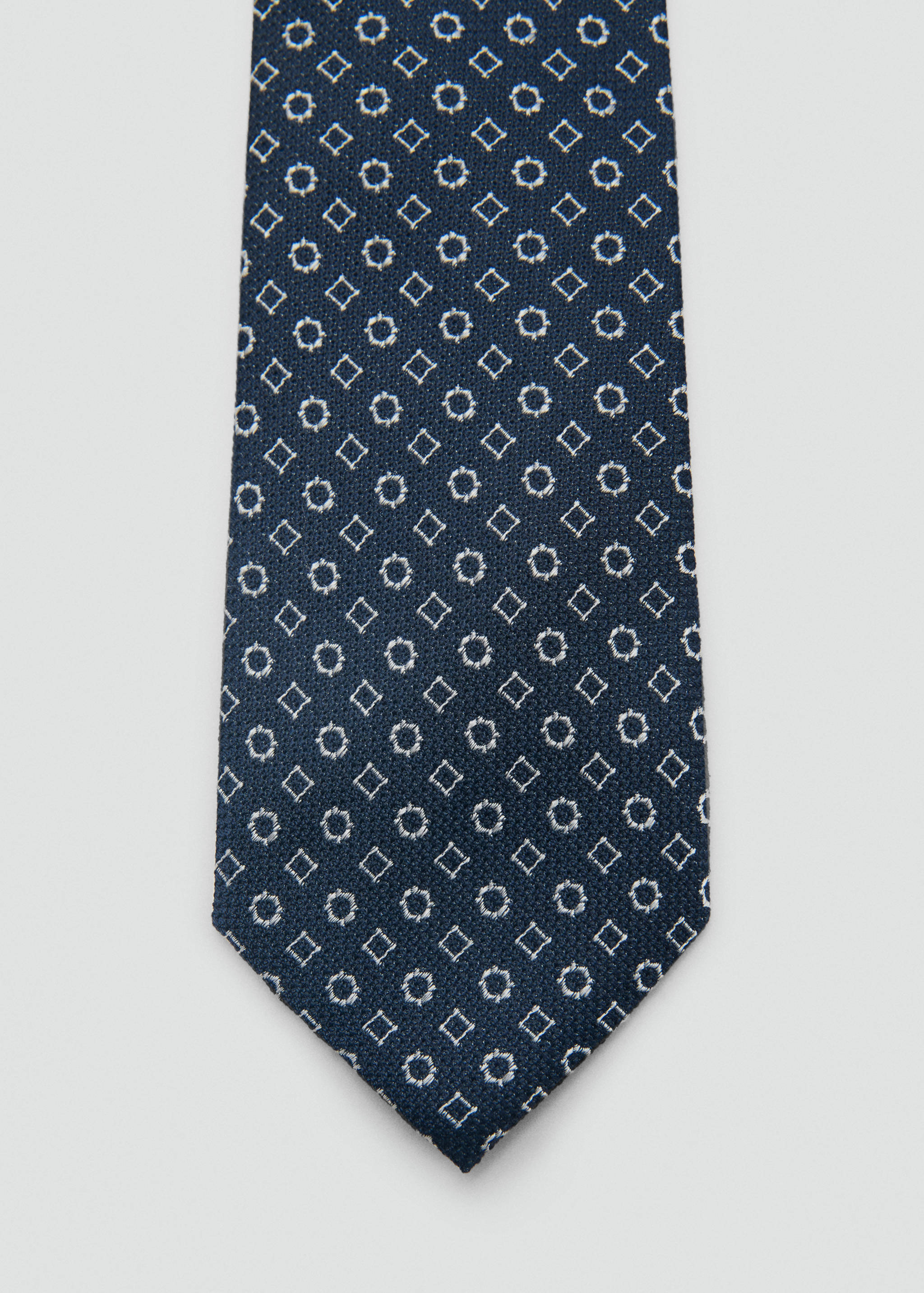 Navy blue tie with embroidered white geometric pattern.