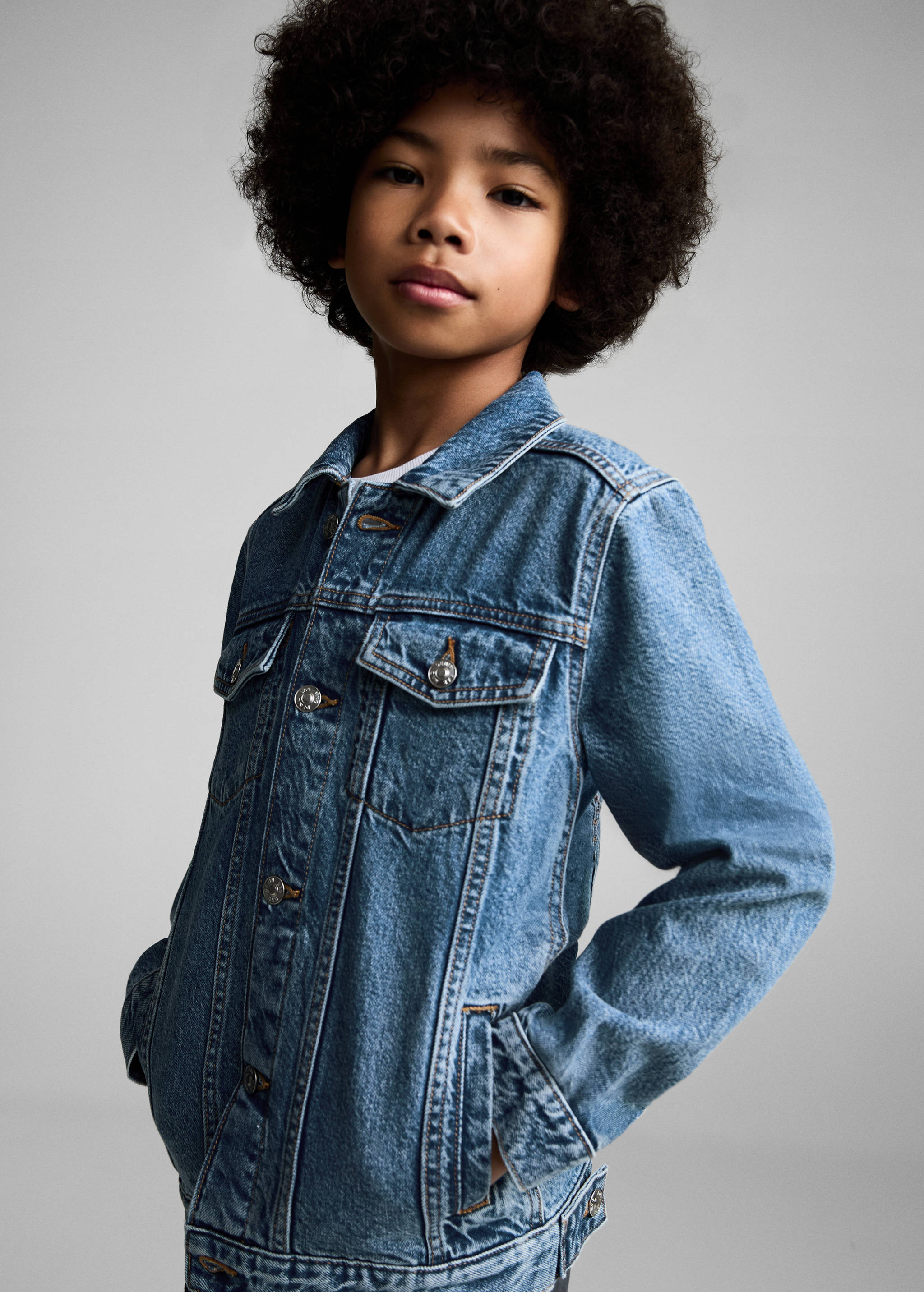 Blue denim jacket with chest flap pockets and metal buttons.