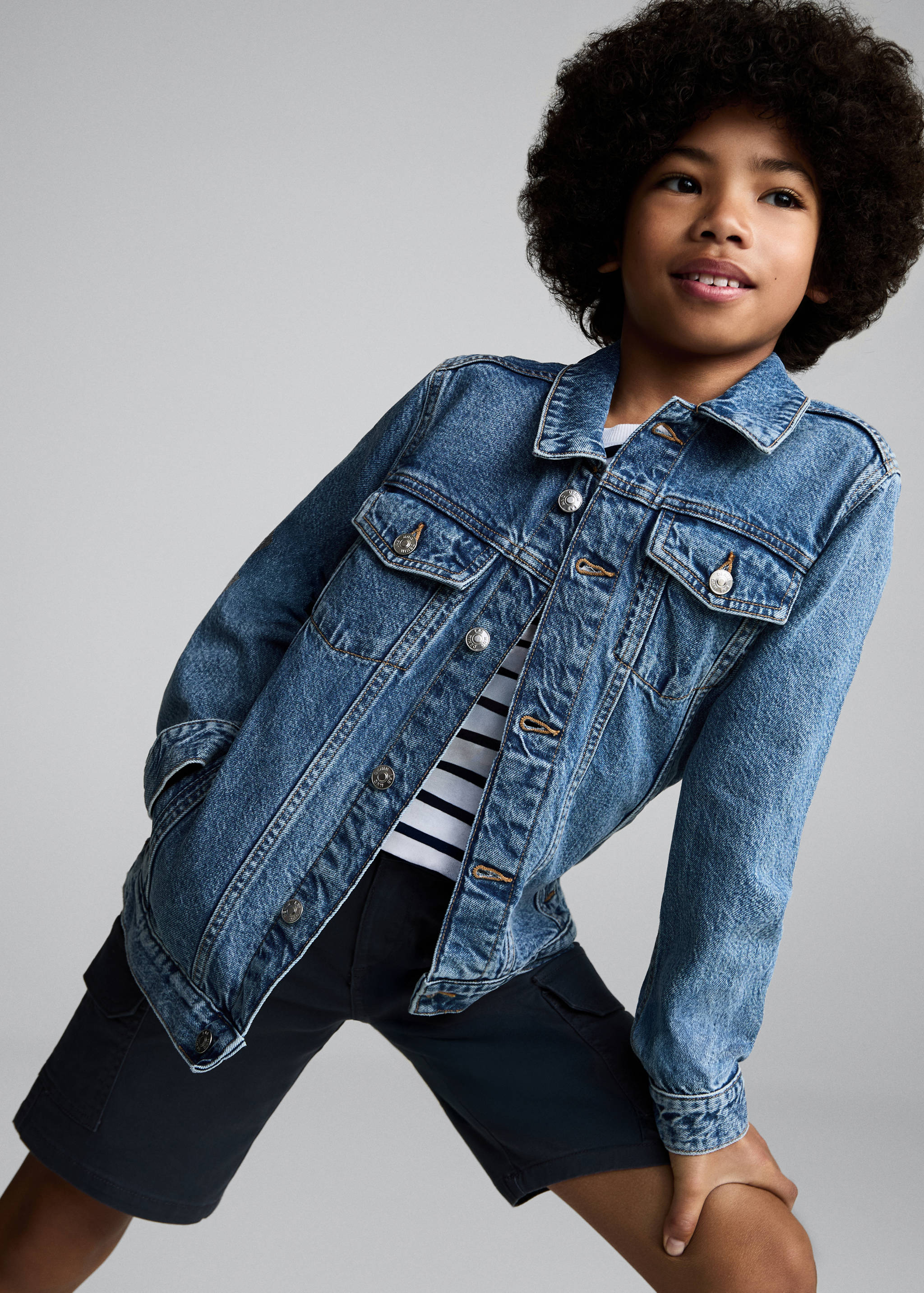 Blue denim jacket with metallic buttons and flap pockets.