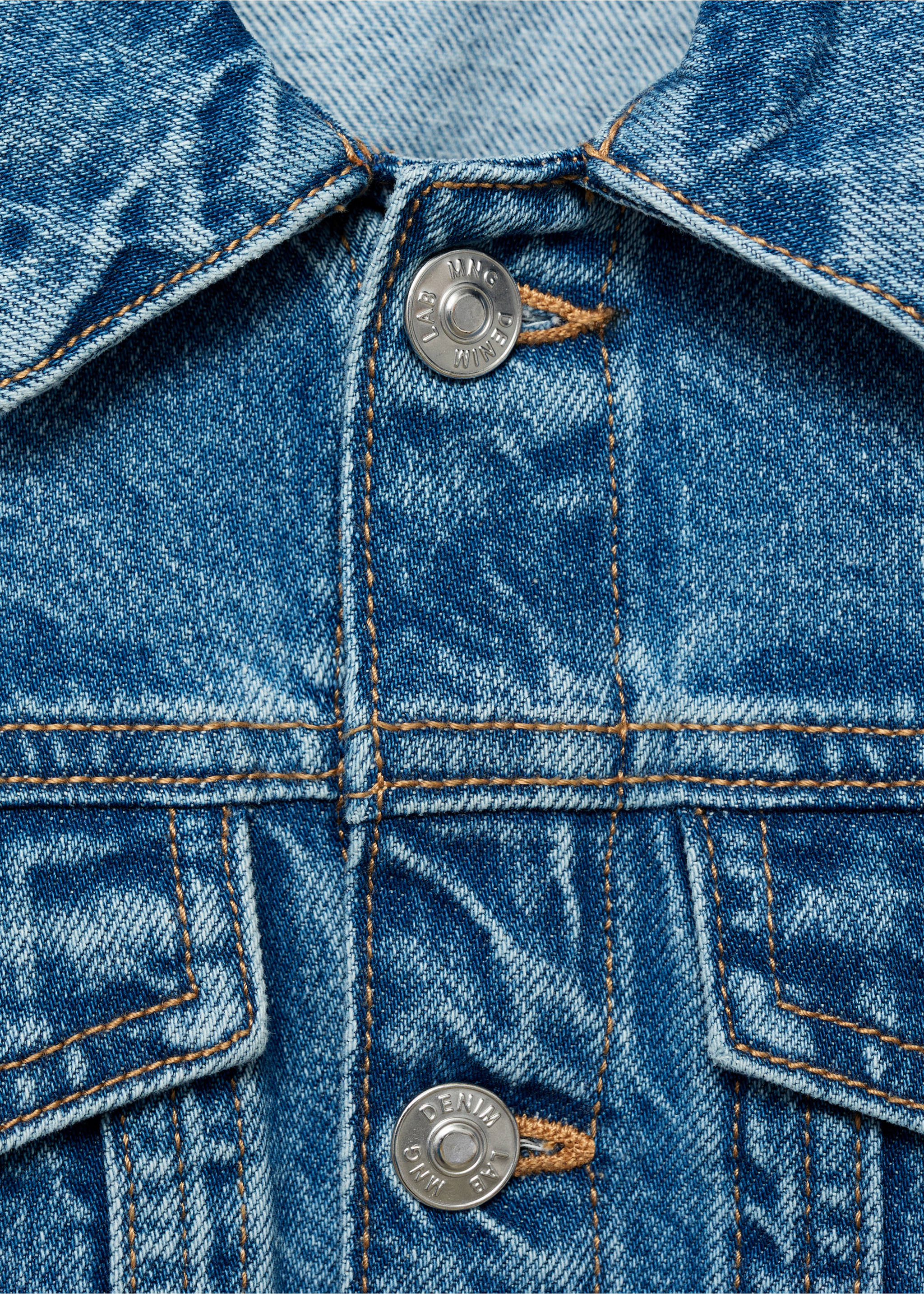 Close-up of a blue denim jacket featuring contrast topstitching and metallic buttons., Medium Blue. Ref: 87045952-00.