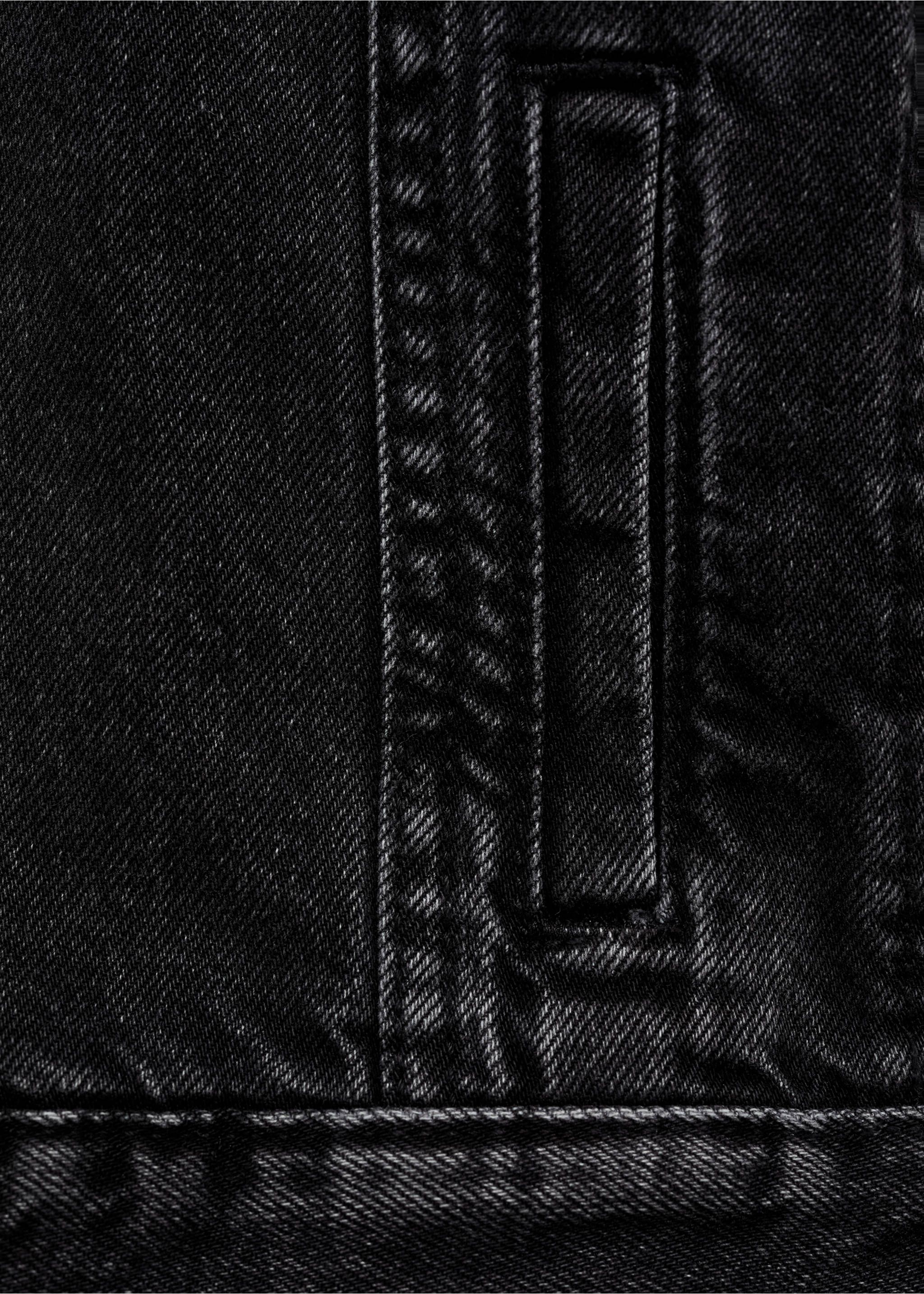 Close-up of black denim jacket fabric featuring a pocket and topstitching., Black denim. Ref: 87045952-00.