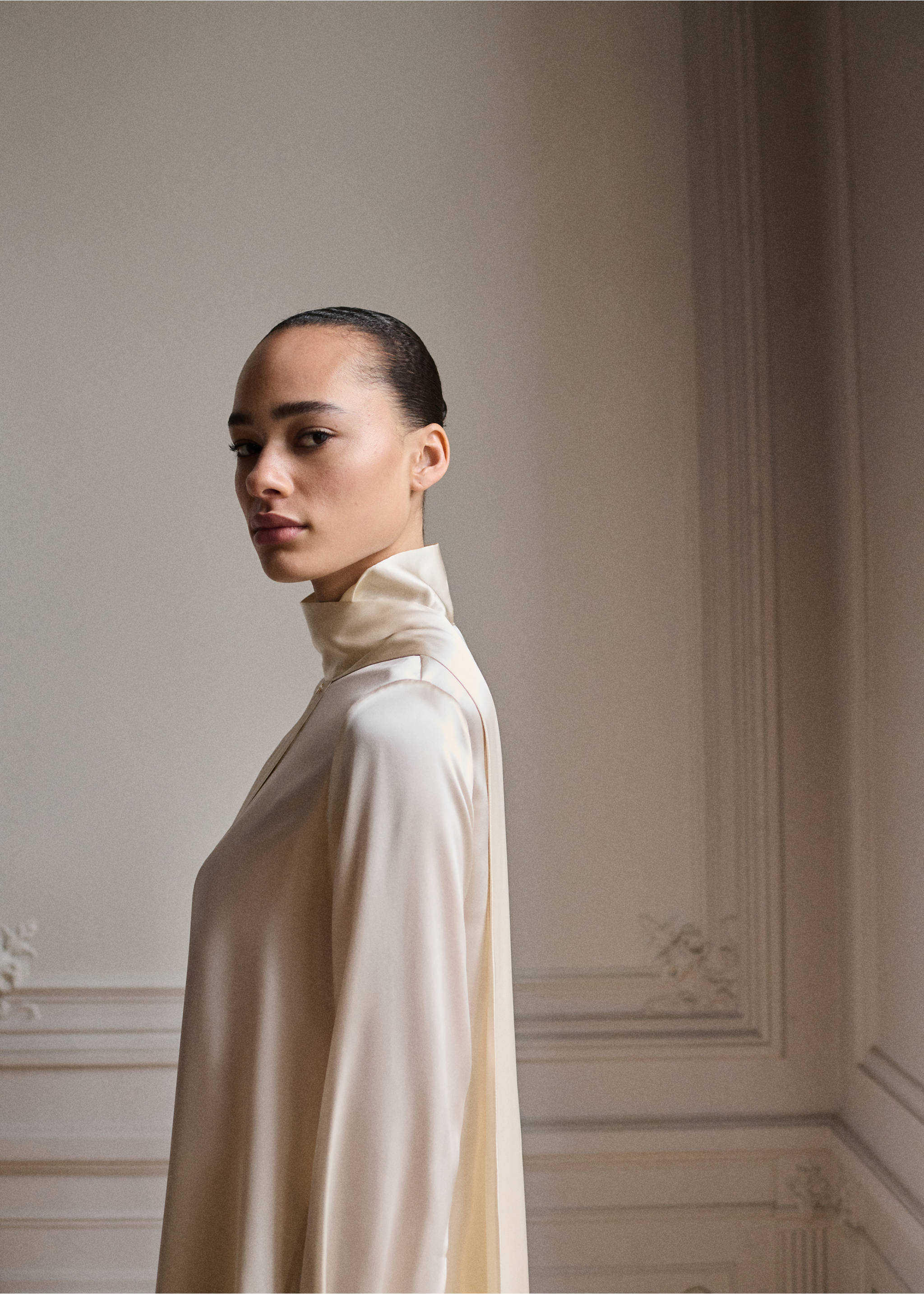 Cream satin shirt with a high collar and draped back panel, shown in a close-up portrait., Ecru. Ref: 87045969-00.