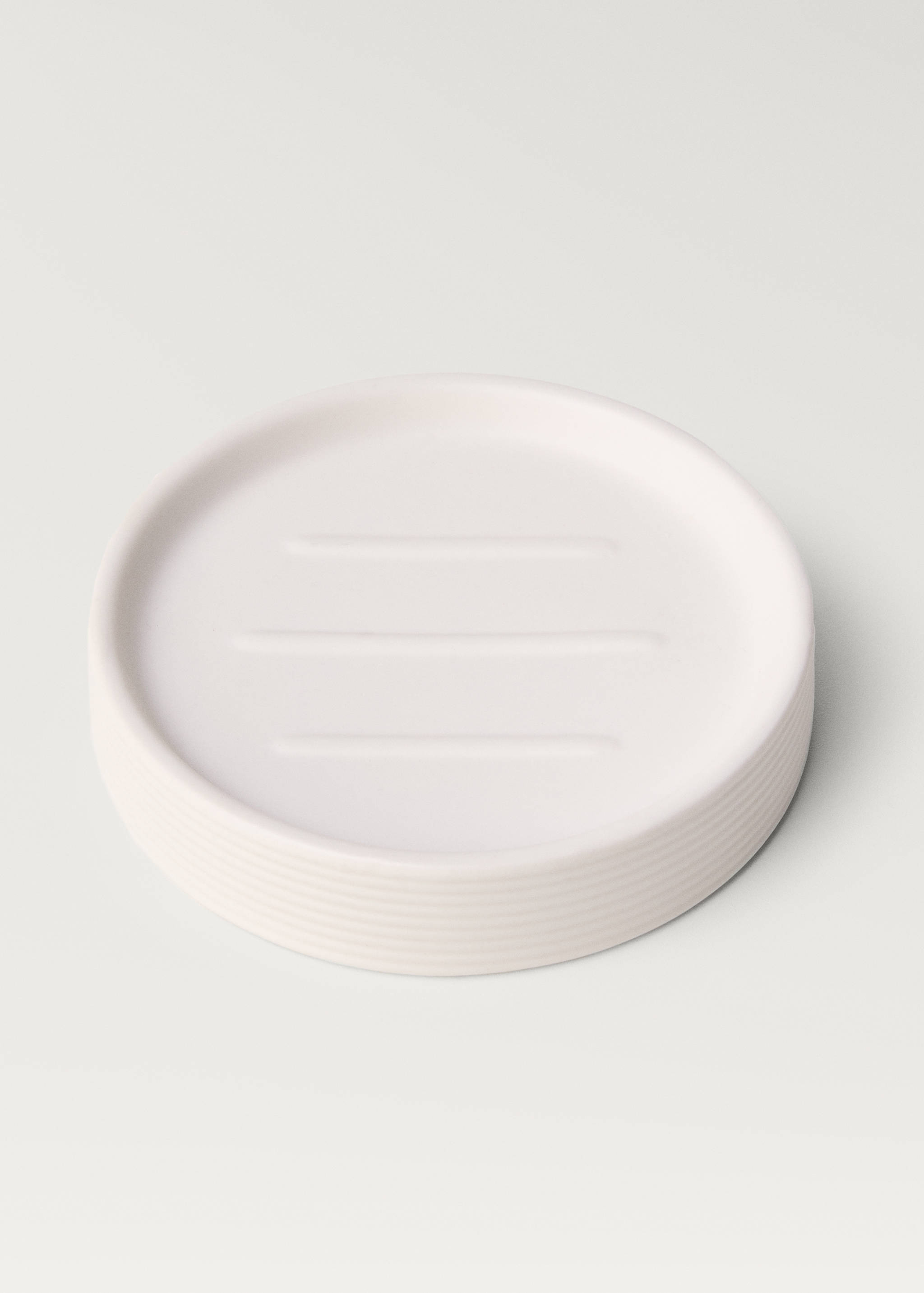 White round soap dish with ribbed edge and drainage ridges.