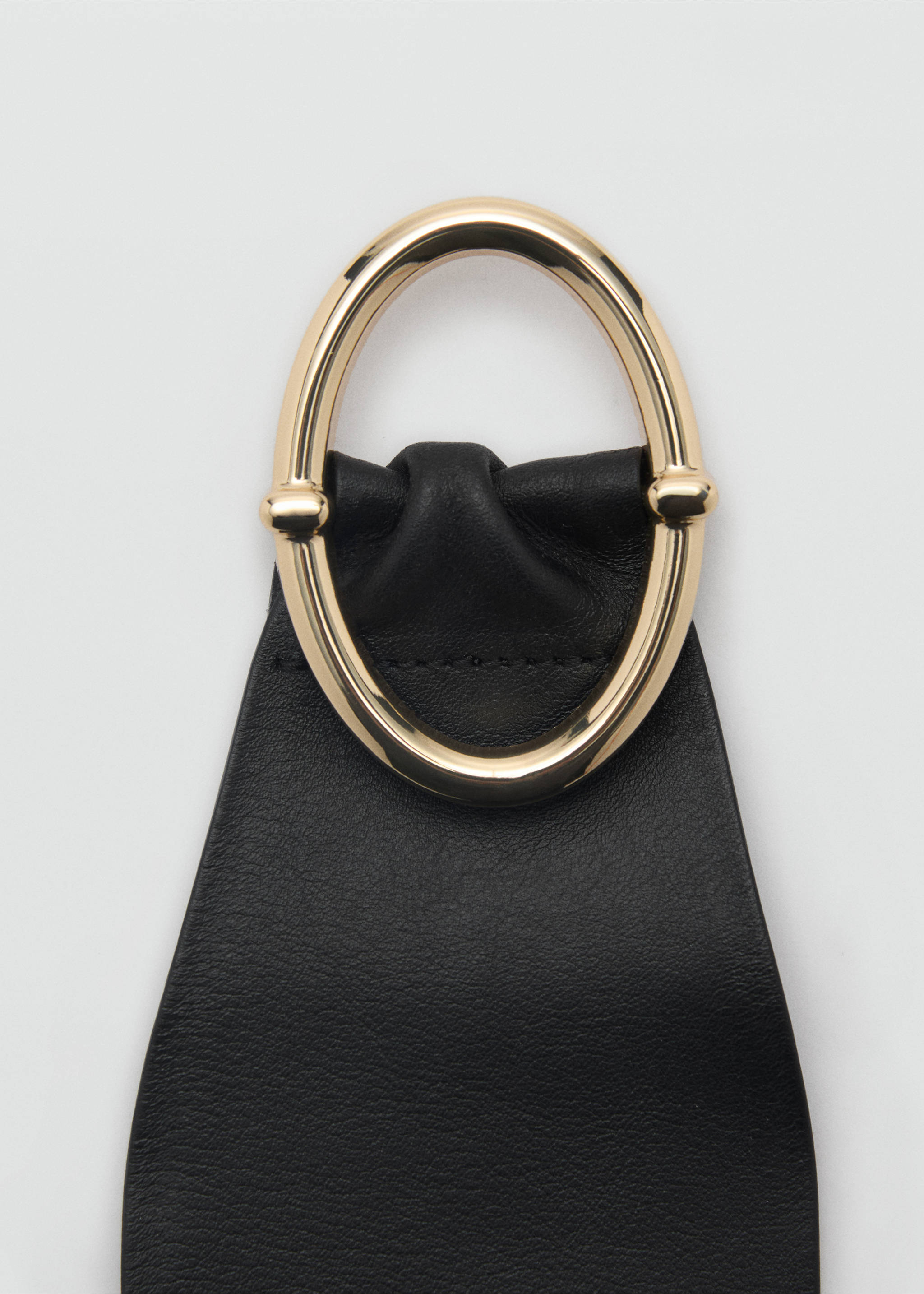 Close-up of a black leather belt with a polished gold-tone oval metal buckle., Black. Ref: 87060422-00.