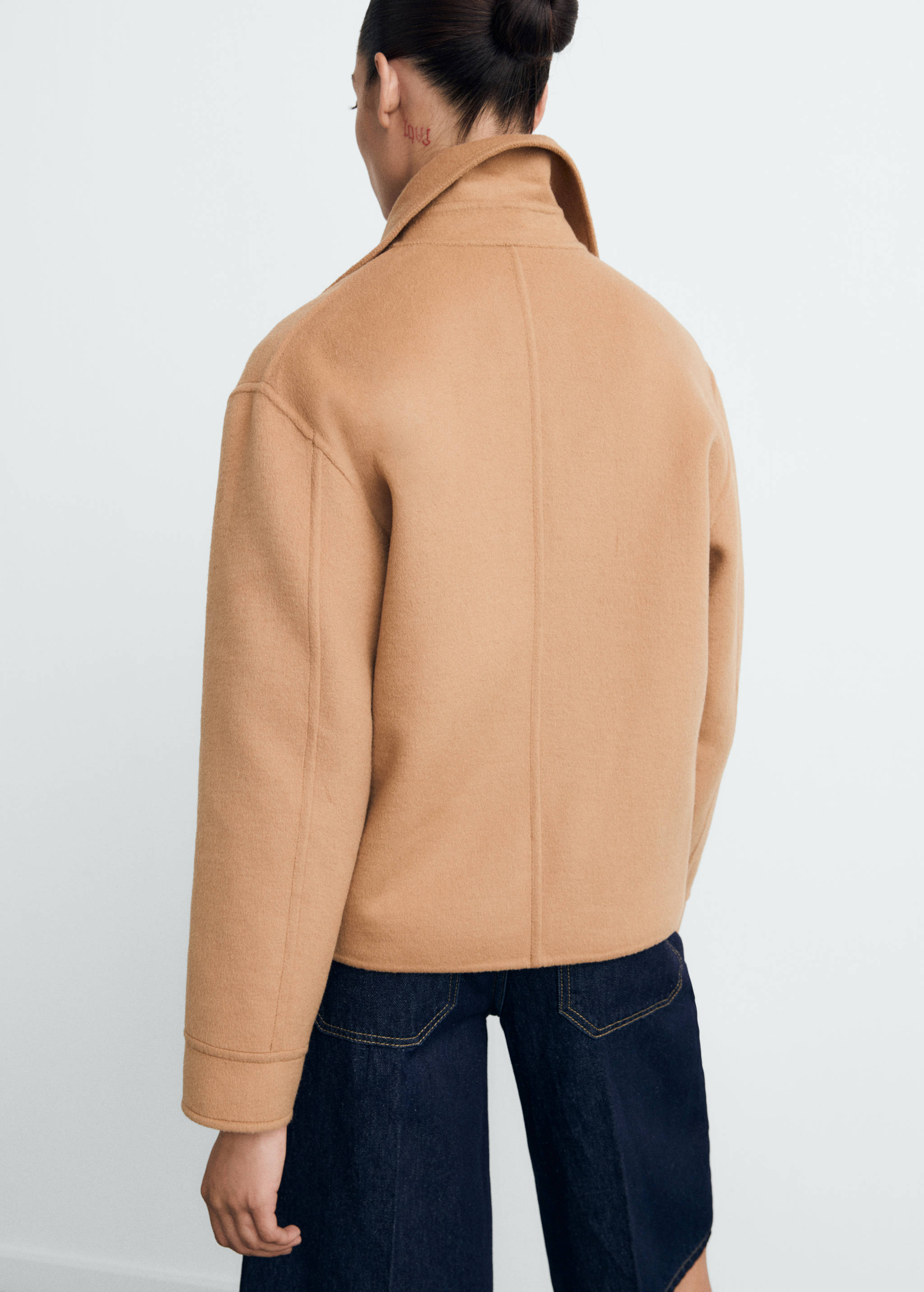 Camel-coloured jacket viewed from the back, featuring a lapel collar and long sleeves.