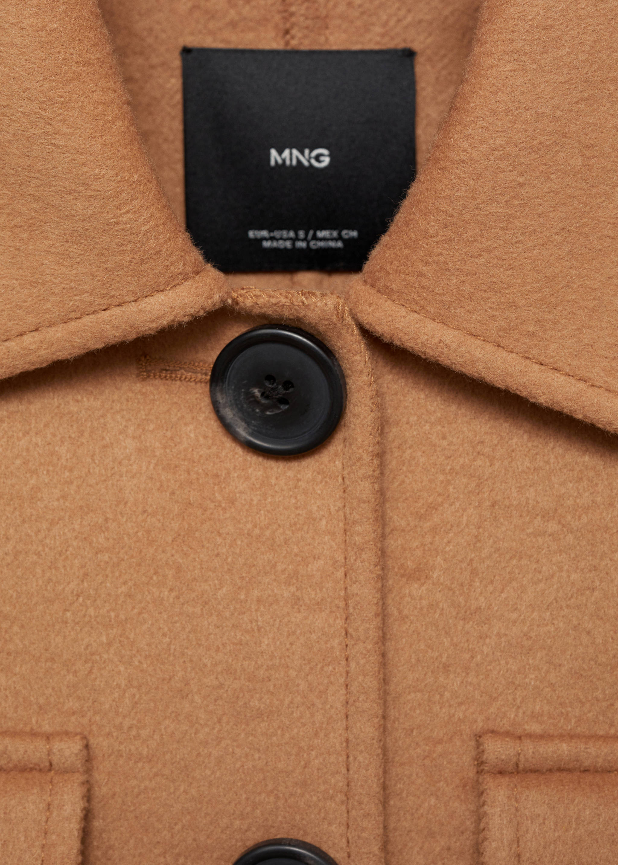 Close-up of the brown jacket collar and black button detail.