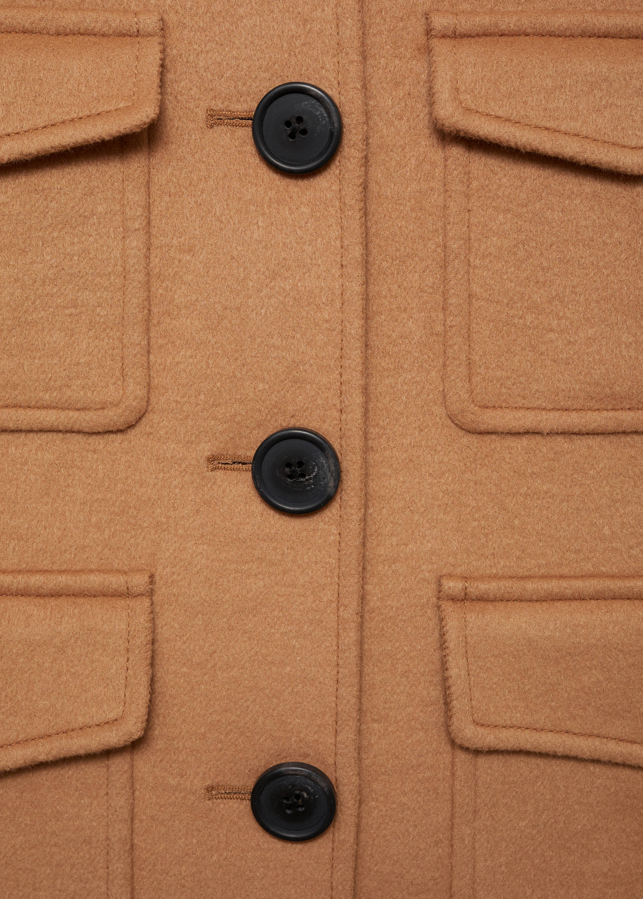 Camel jacket fabric and button detail with patch pockets.
