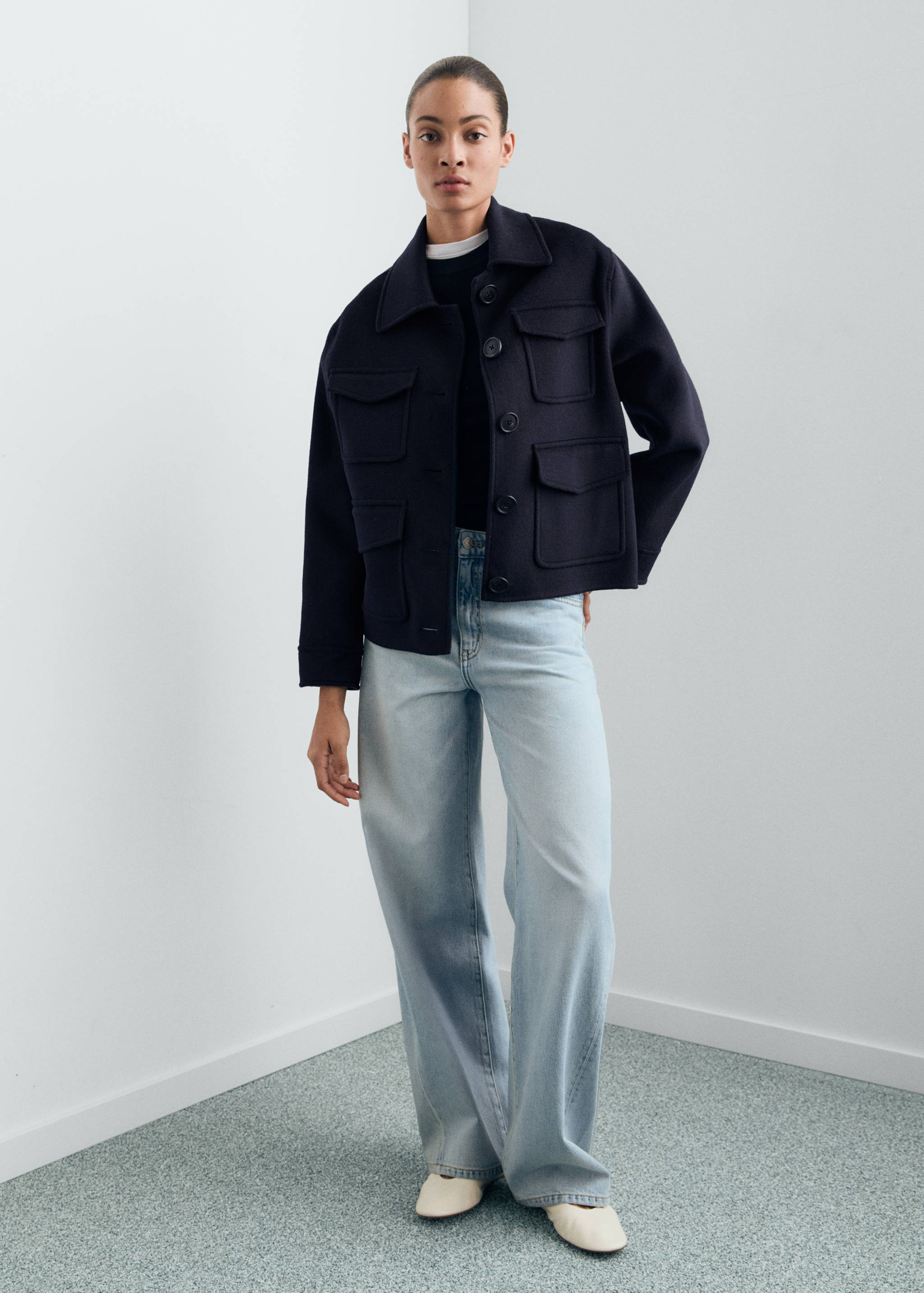 Navy blue cropped jacket with a point collar, front buttons, and four flap pockets.