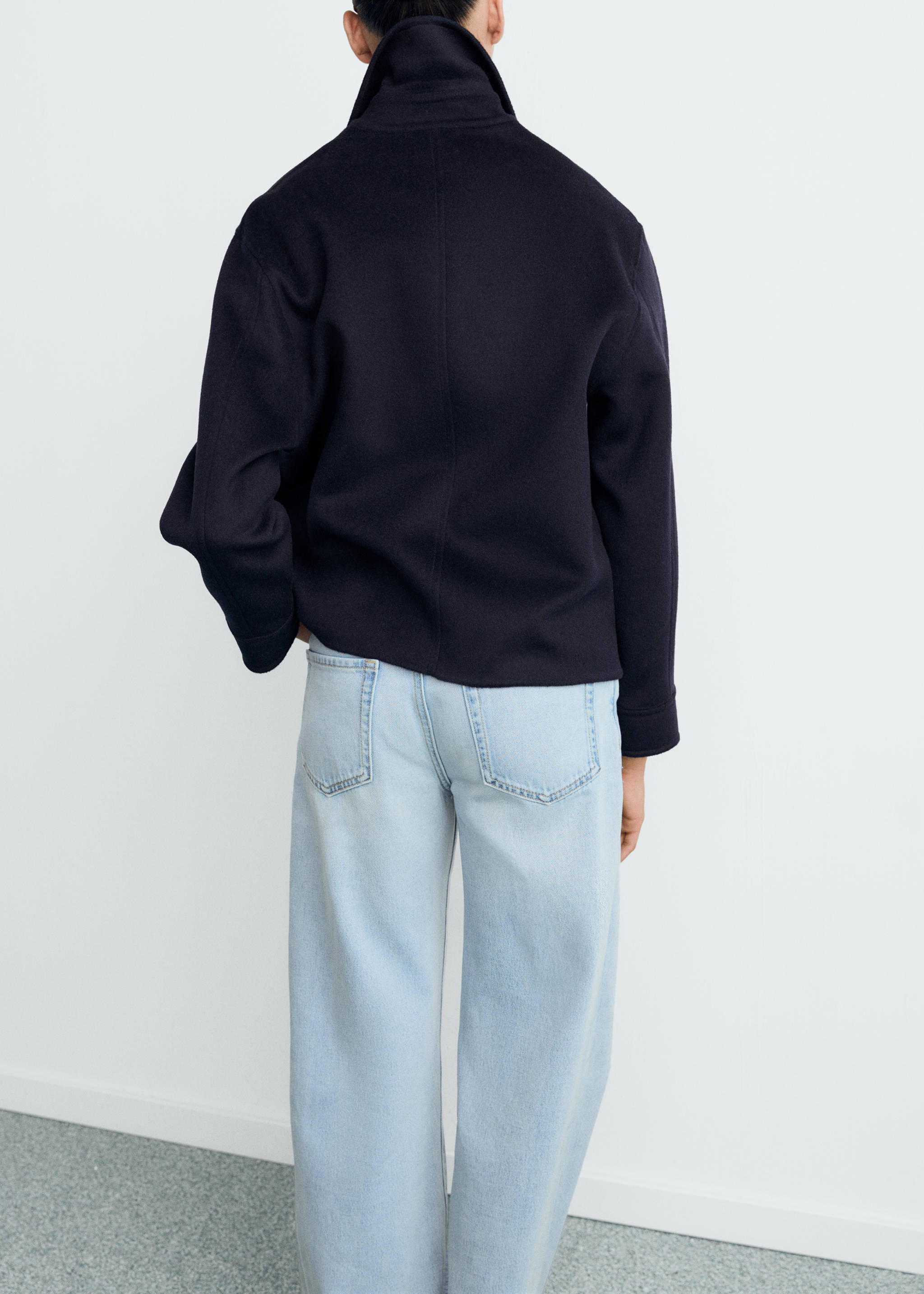 Navy blue jacket with high collar, shown from the back.