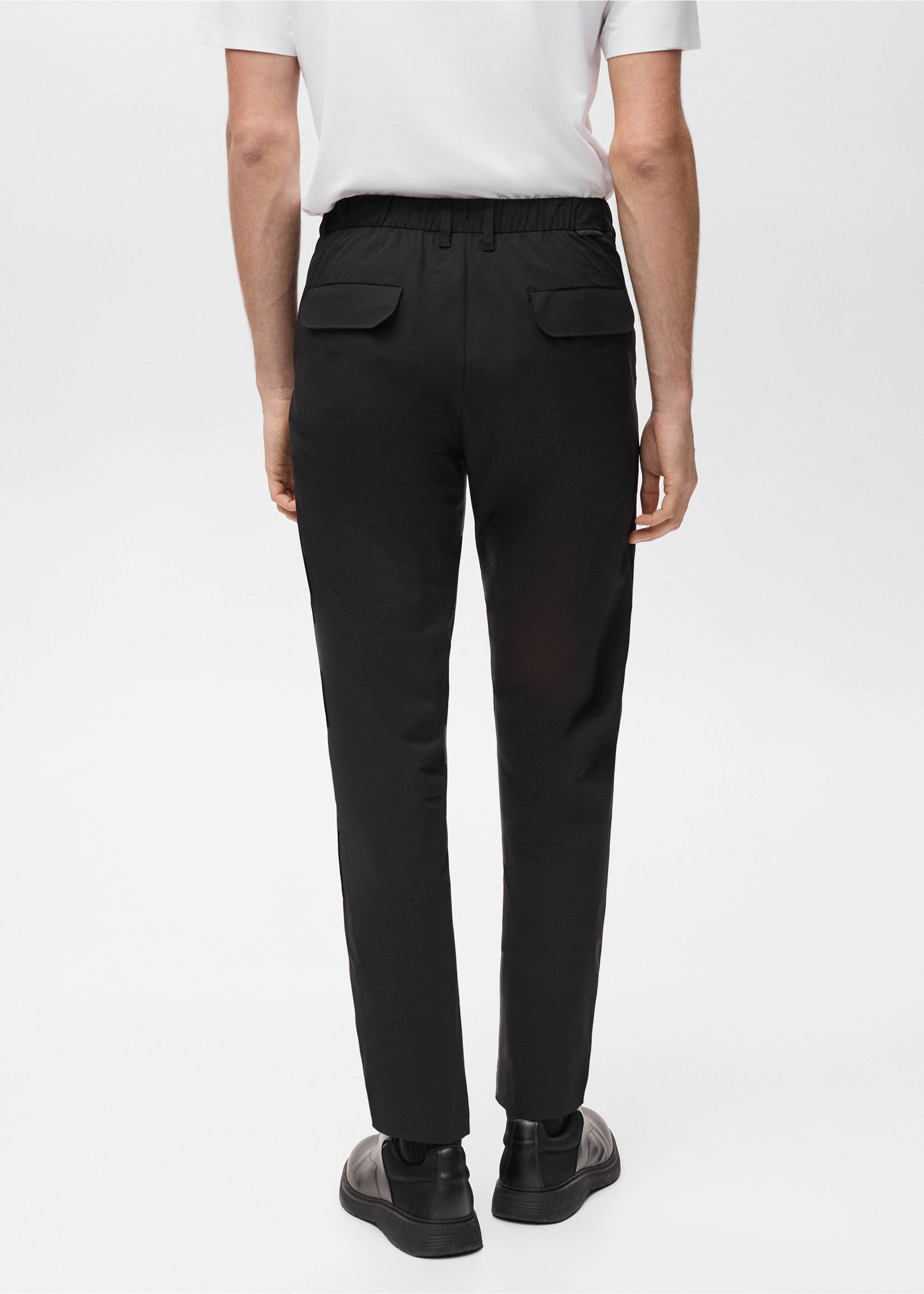 Black trousers featuring an elasticated waistband and back flap pockets, shown from the back., Black. Ref: 87064389-00.