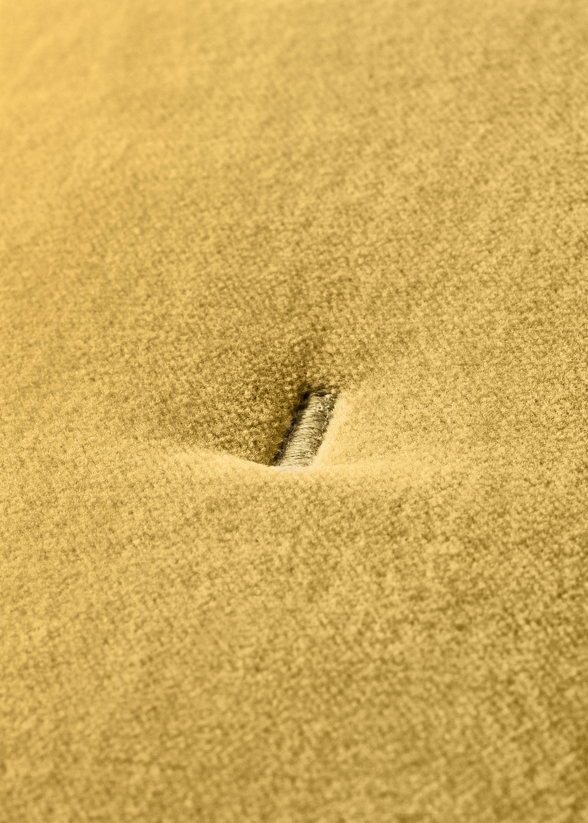 Mustard yellow cushion cover buttonhole detail.