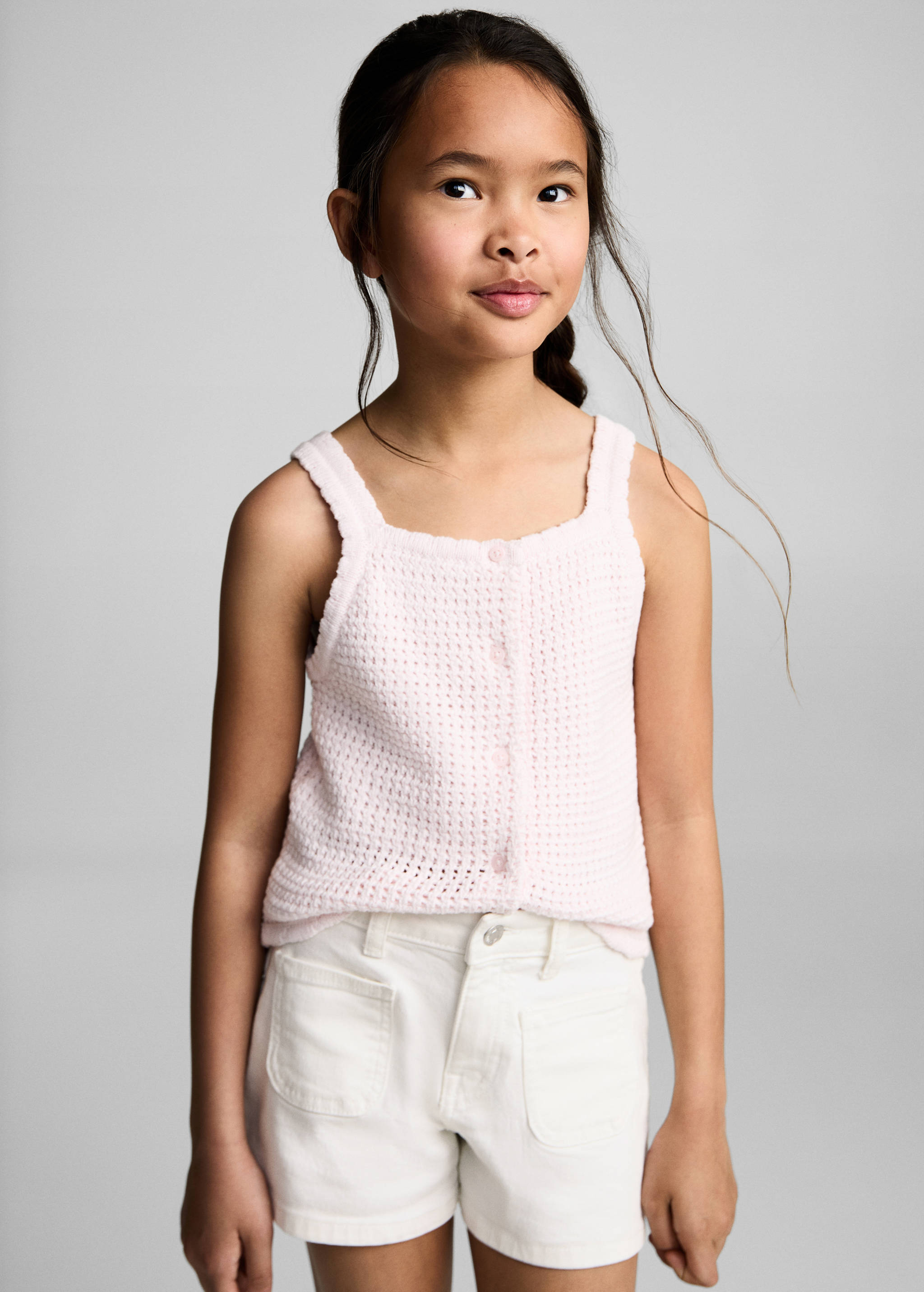 White denim shorts with front patch pockets, worn with a pink knit top.