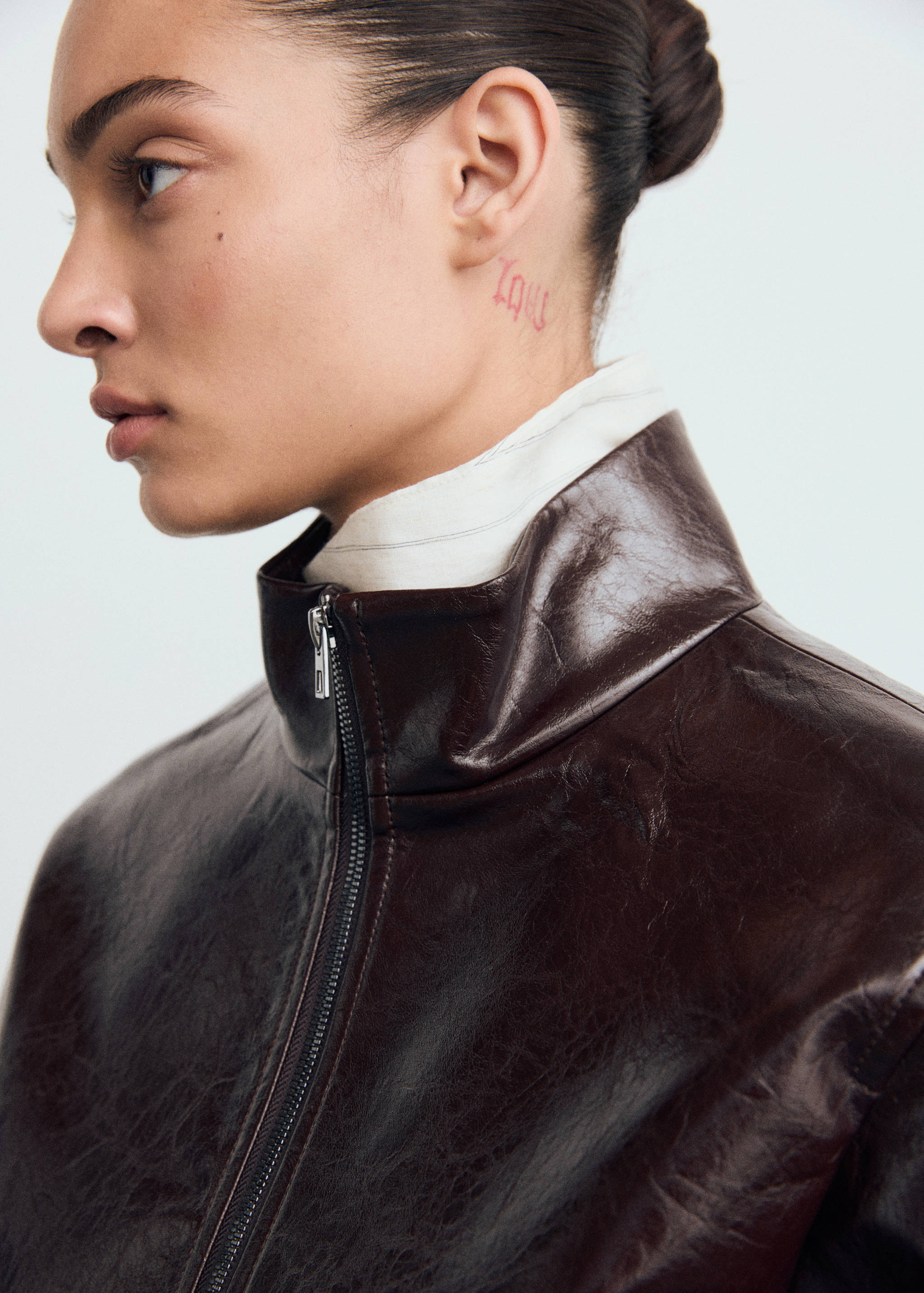 Dark brown glossy jacket with a high collar and front zip.