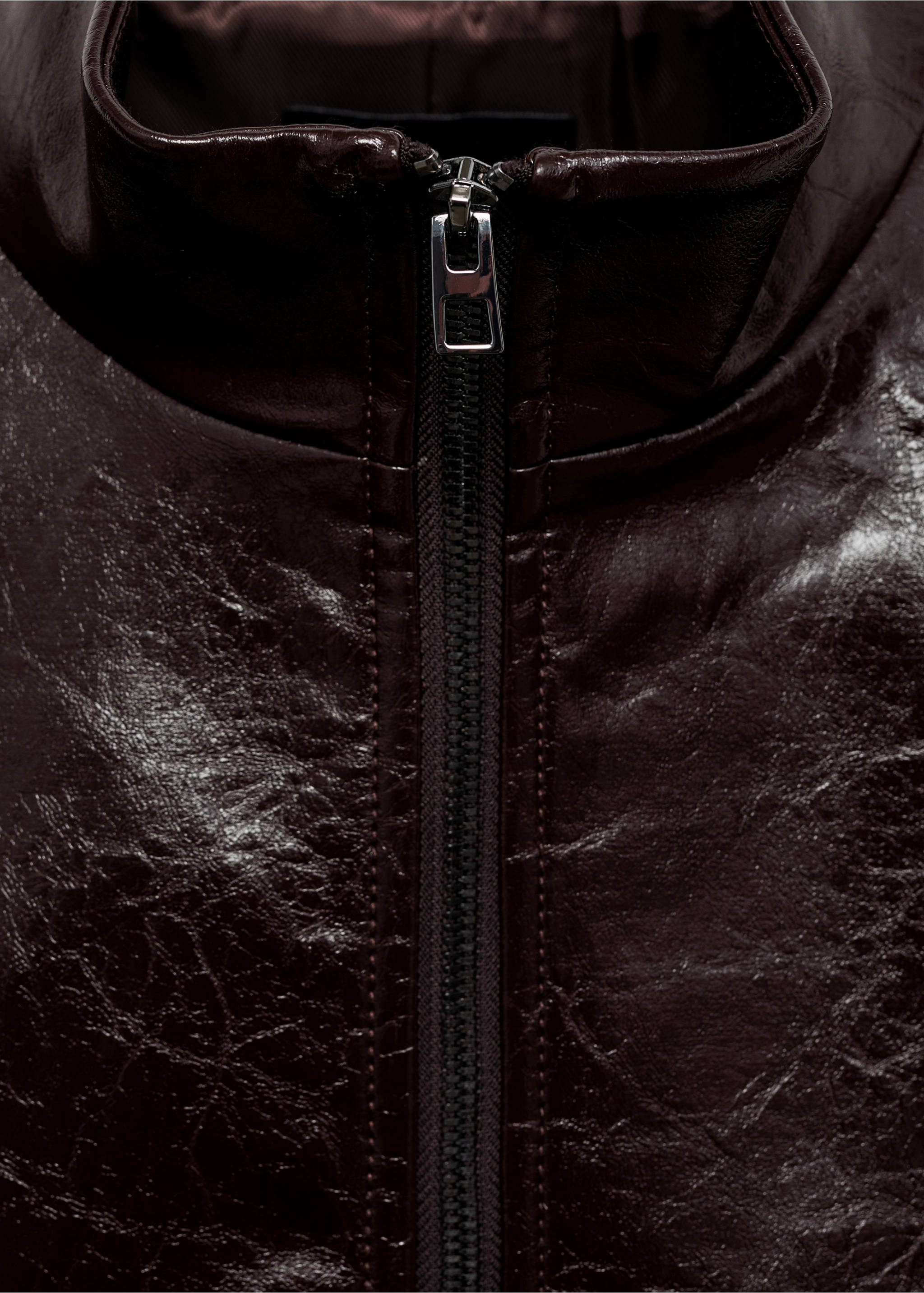 Close-up of a dark burgundy jacket with a high collar and zipper., Brown. Ref: 87070640-00.