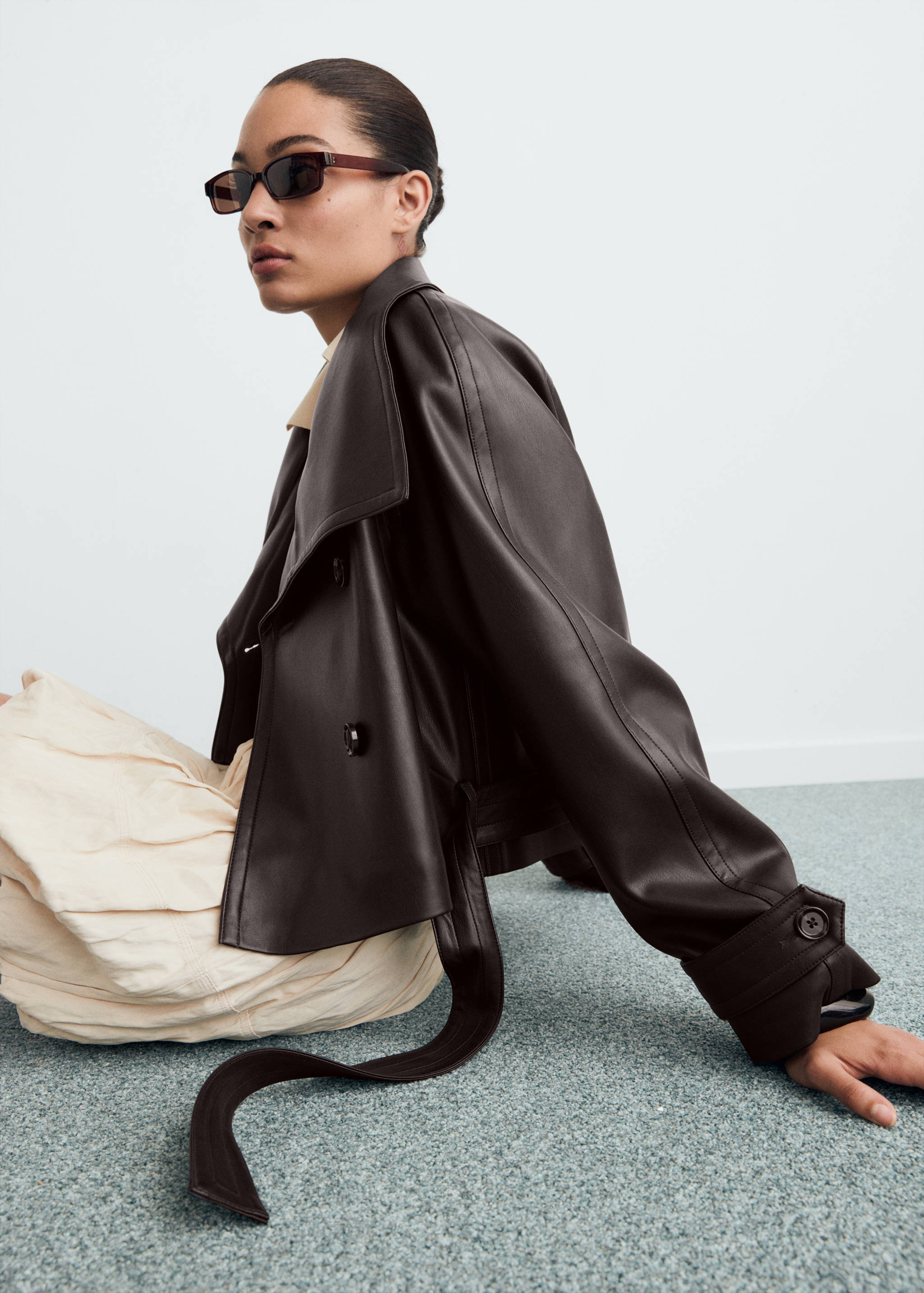 Dark brown faux-leather cropped jacket with wide lapels and belt.