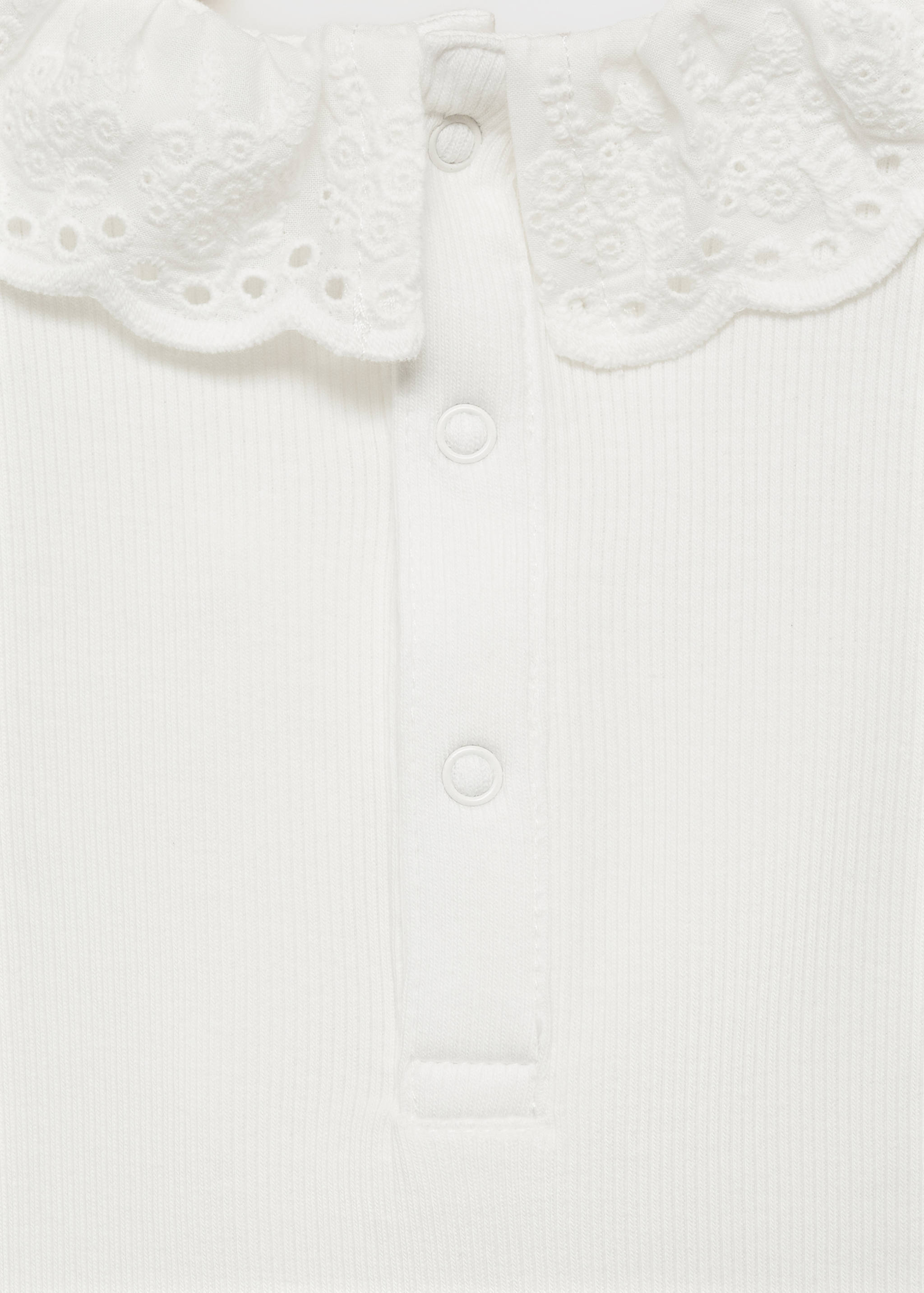 White baby body detail with ribbed knit, snap placket and lace collar.