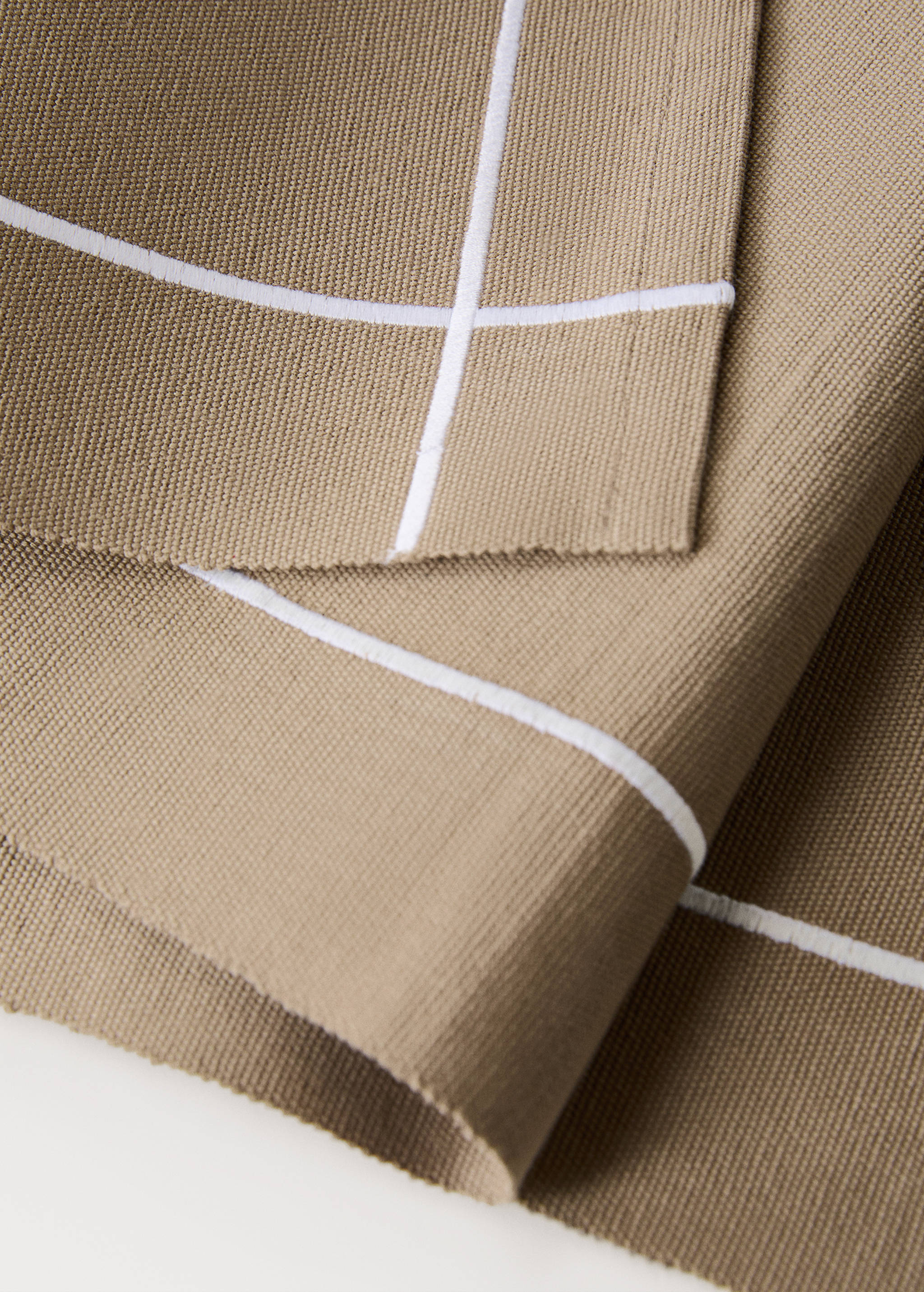 Beige woven table runner detail with white stripe pattern.