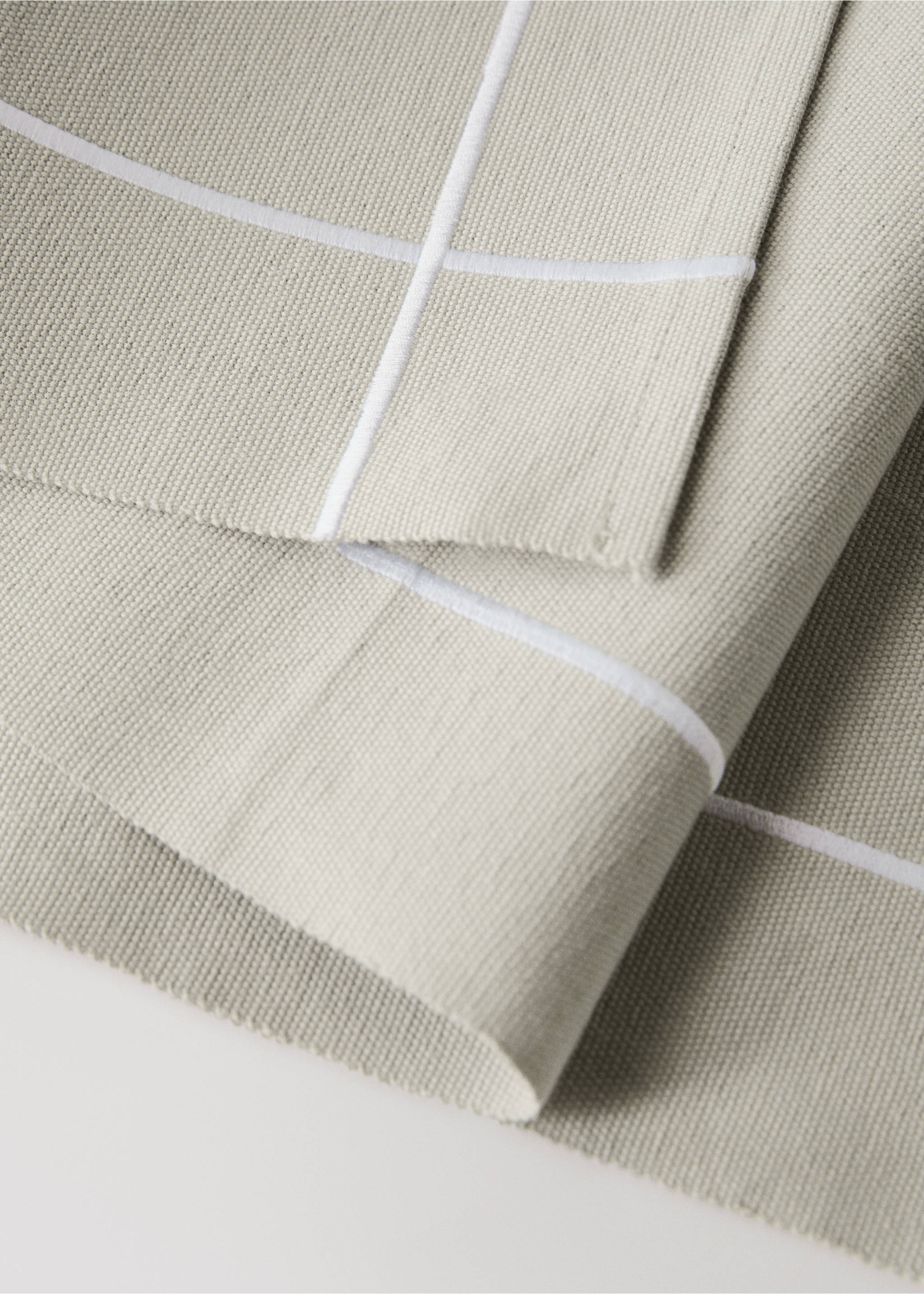 Close-up of a beige textured table runner with a white border., Light/Pastel Grey. Ref: 87082977-00.